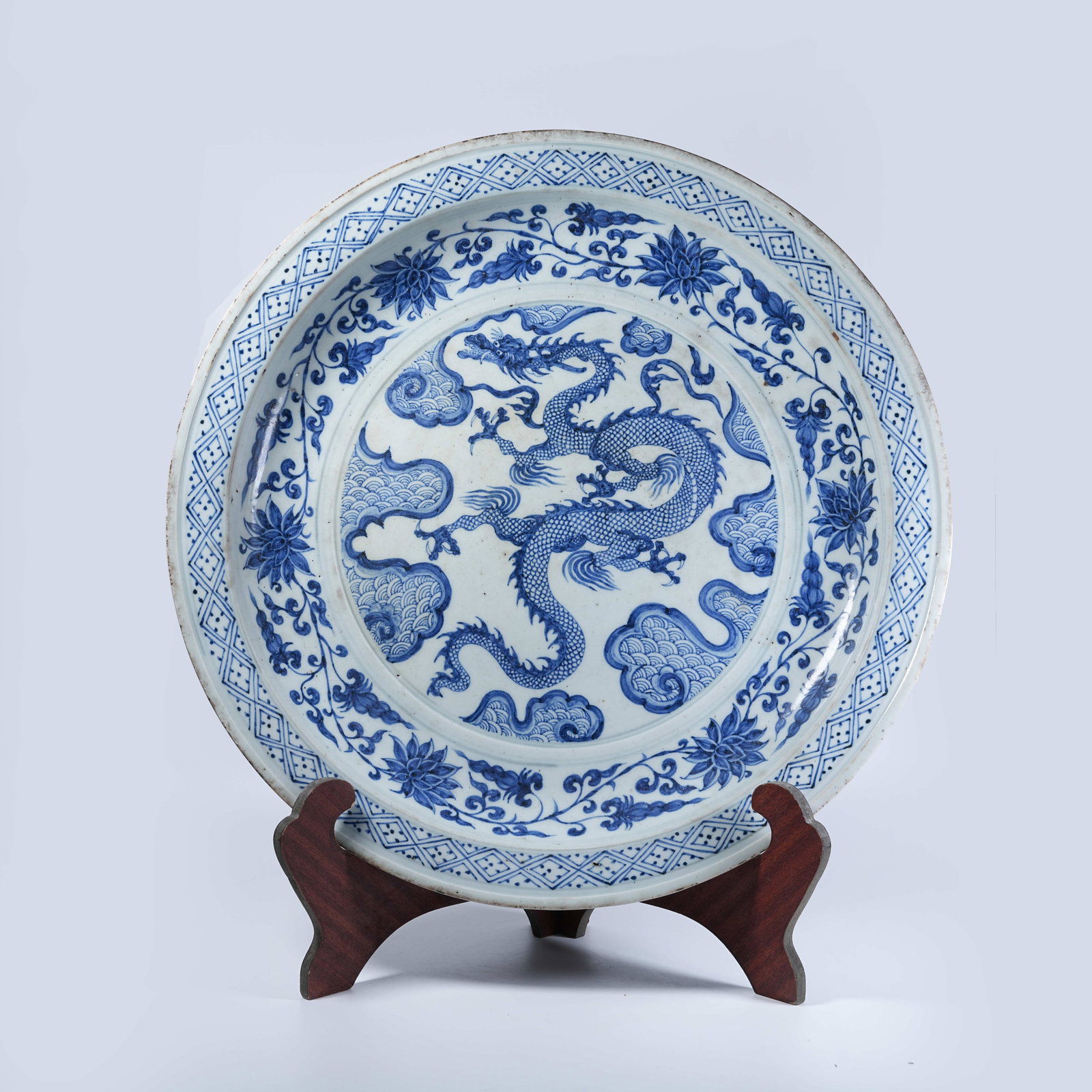 A WIDE-RIMMED LARGE PLATE WITH BLUE AND WHITE CLOUD DRAGON PATTERNS: Wide-Rimmed Large Plate with Blue and White Cloud Dragon Patterns