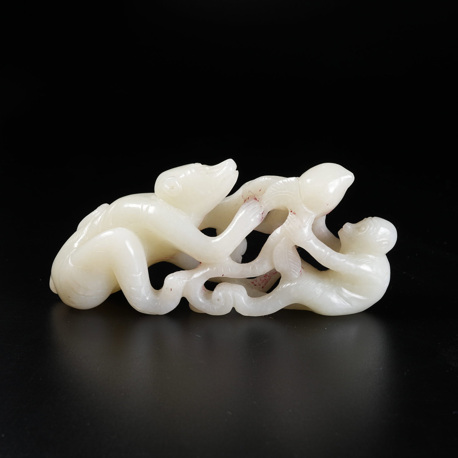 A HETIAN JADE ORNAMENT OF MONKEY PRESENTING LONGEVITY PEACH: Hetian Jade Ornament of Monkey Presenting Longevity Peach