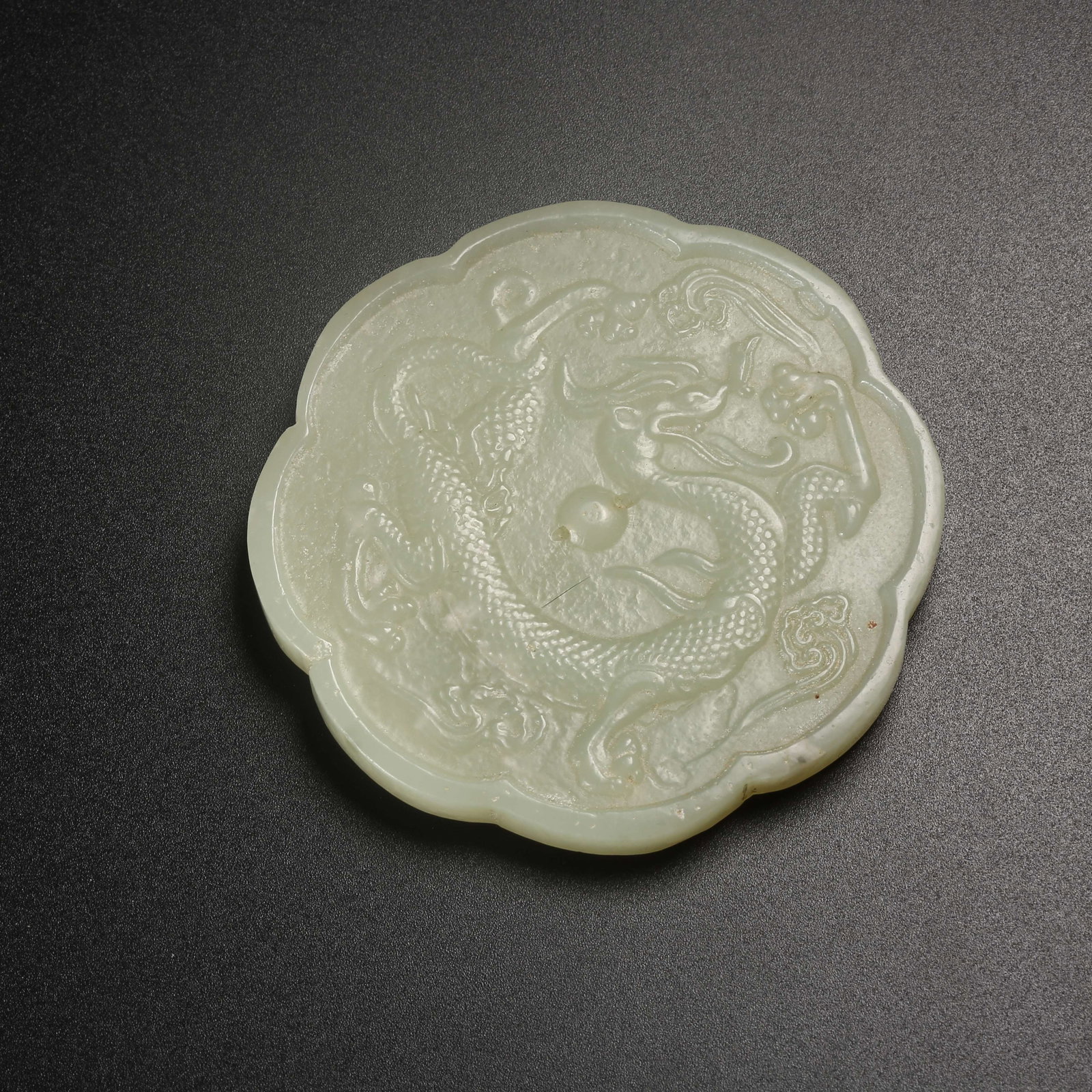 A HETIAN JADE MIRROR CARVED WITH DRAGON MOTIFS: Hetian jade mirror carved with dragon motifs