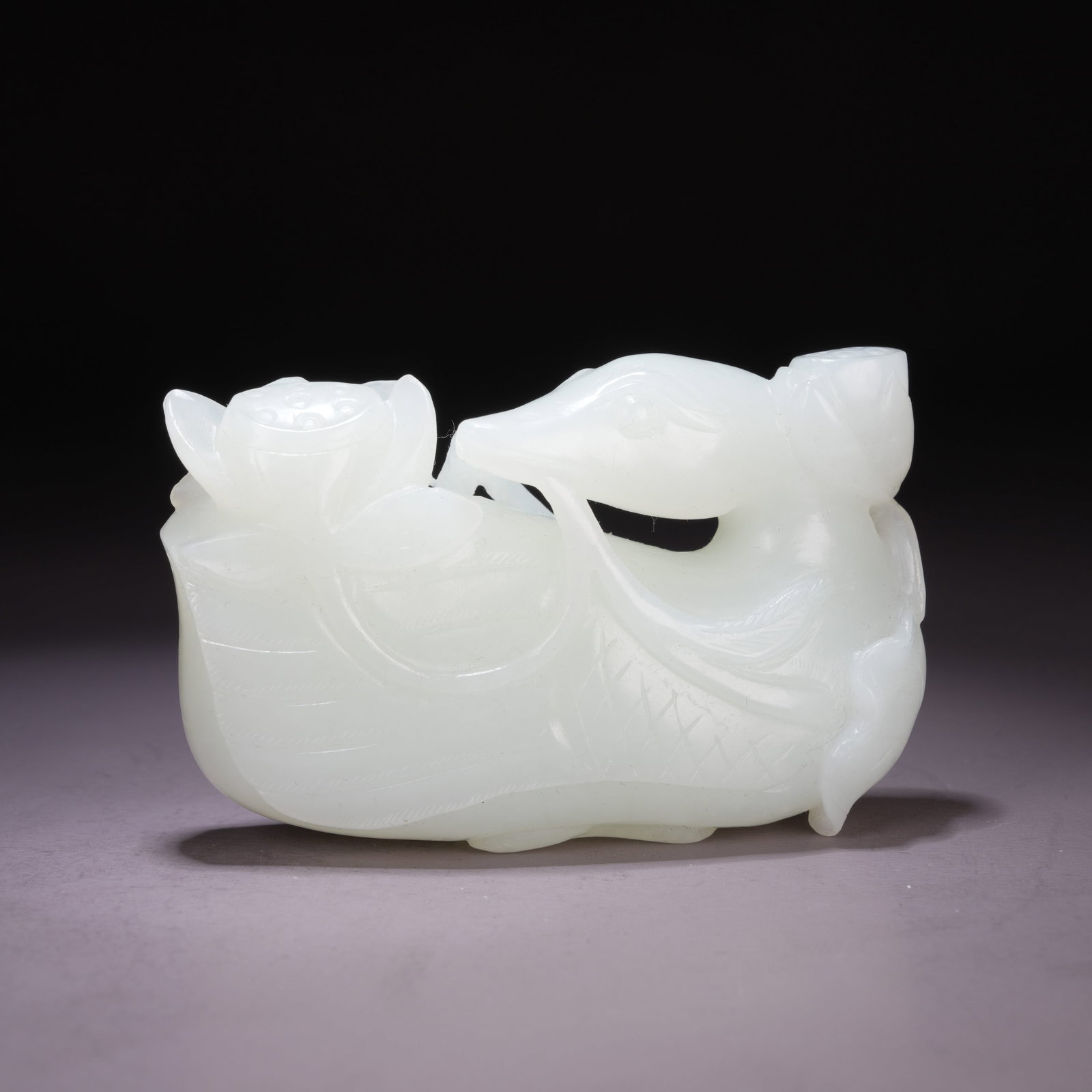 A HETIAN WHITE JADE ORNAMENT OF A TREASURE DUCK HOLDING A LOTUS BLOSSOM (1 of 9)