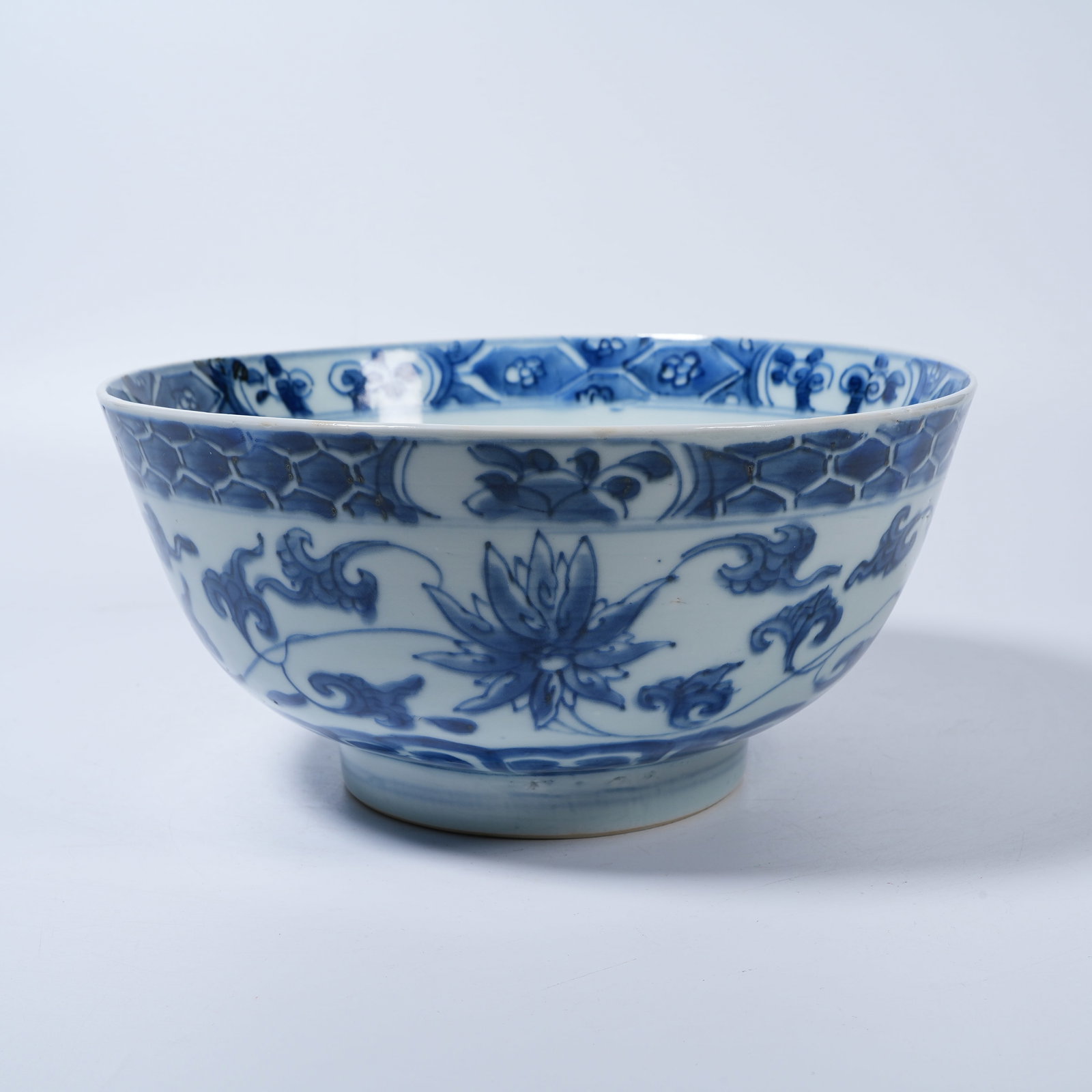 A BLUE AND WHITE BOWL WITH INTERLOCKING FLORAL SCROLLS: Blue and White Bowl with Interlocking Floral Scrolls
