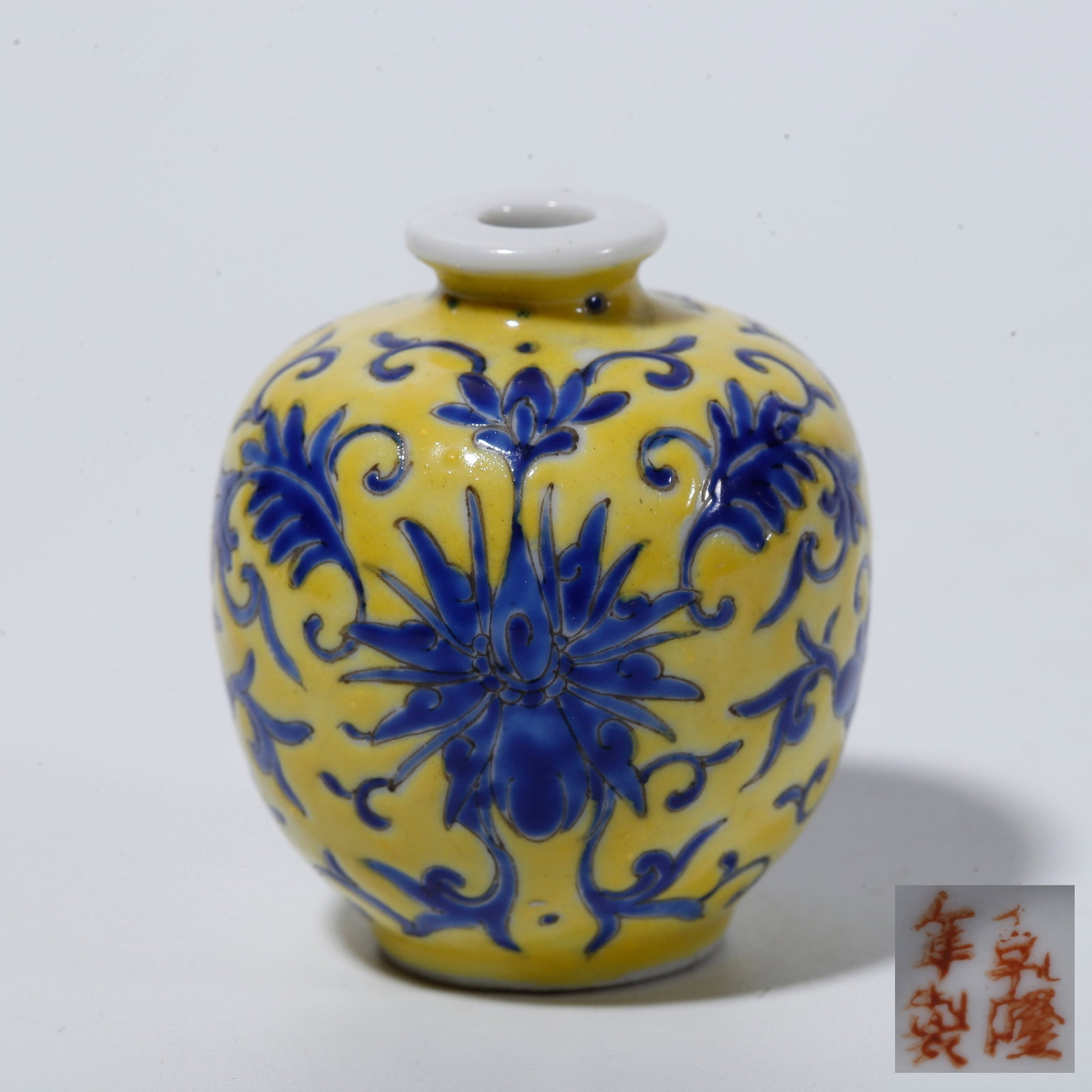 A YELLOW GROUND BLUE GLAZE SNUFF BOTTLE WITH INTERLOCKING FLORAL SCROLLS: Yellow Ground Blue Glaze Snuff Bottle with Interlocking Floral Scrolls