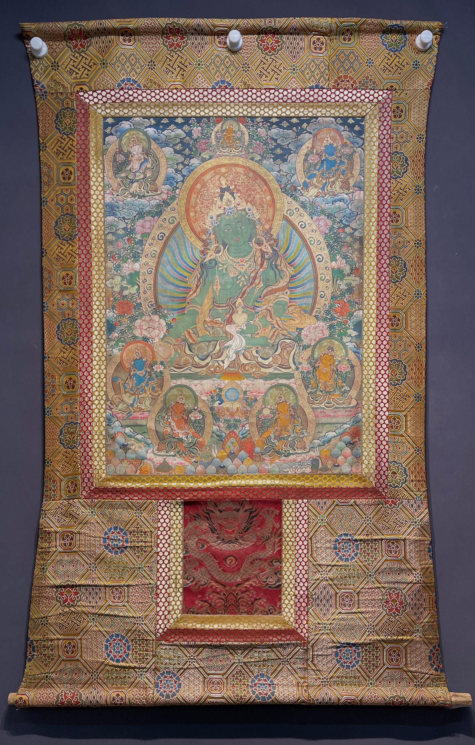A VERTICAL SCROLL LEATHER THANGKA OF GREEN TARA ON PAPER.: Vertical Scroll Leather Thangka of Green Tara on Paper.