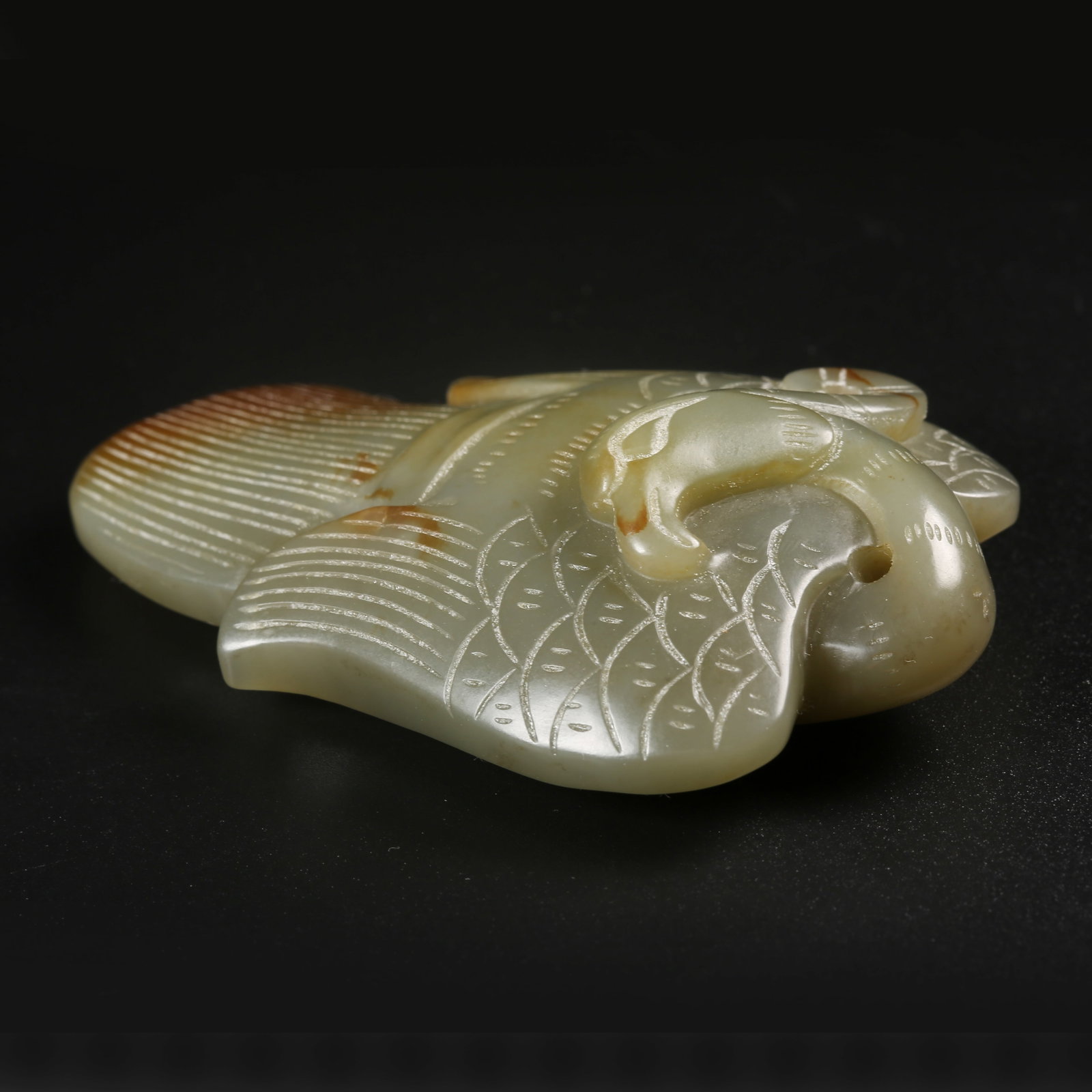 A ARCHAIC JADE HANDHELD CARVING WITH DIVINE PHOENIX MOTIFS: Archaic jade handheld carving with divine phoenix motifs