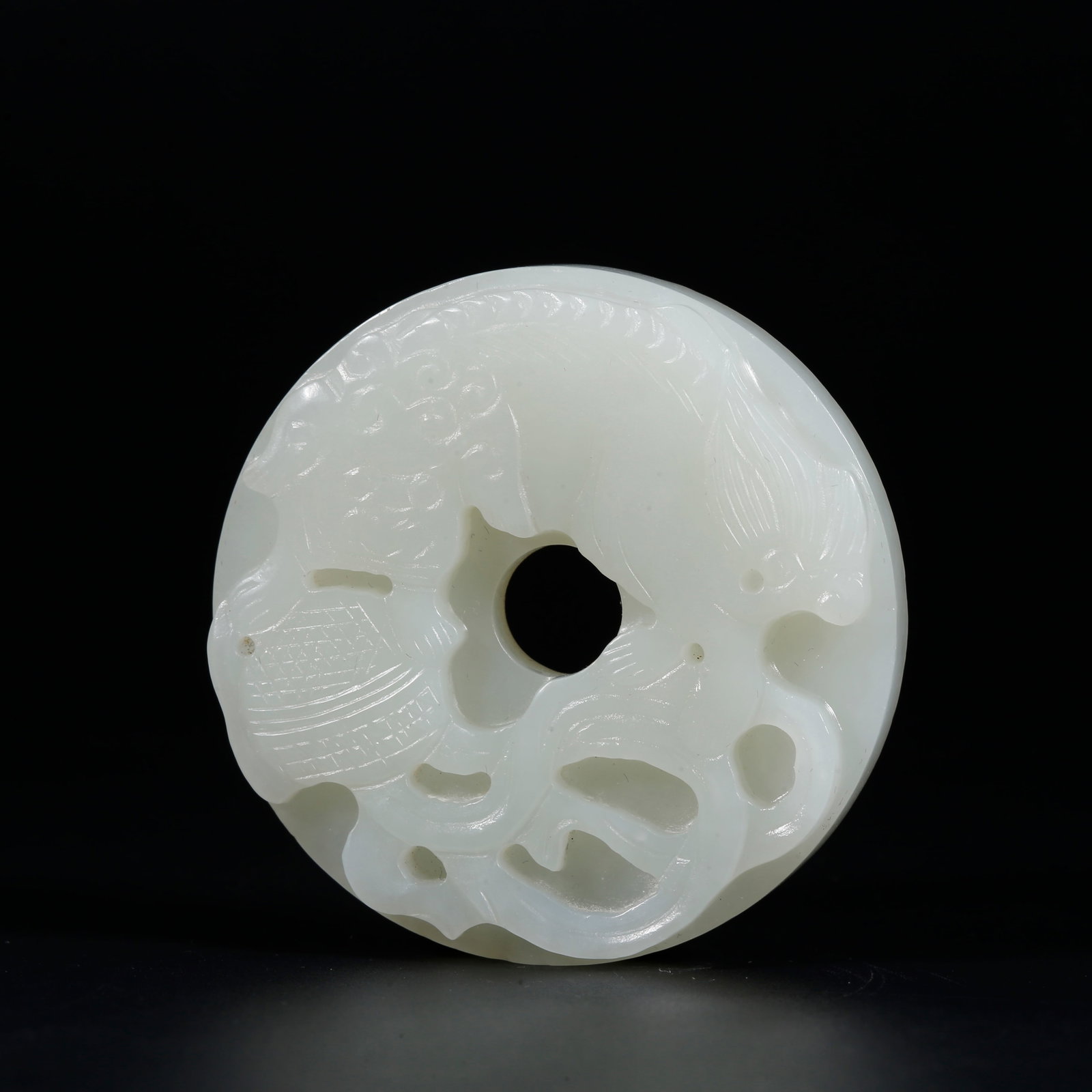 A HETIAN JADE BI DISC CARVED WITH LIONS PLAYING BALL MOTIFS (1 of 9)