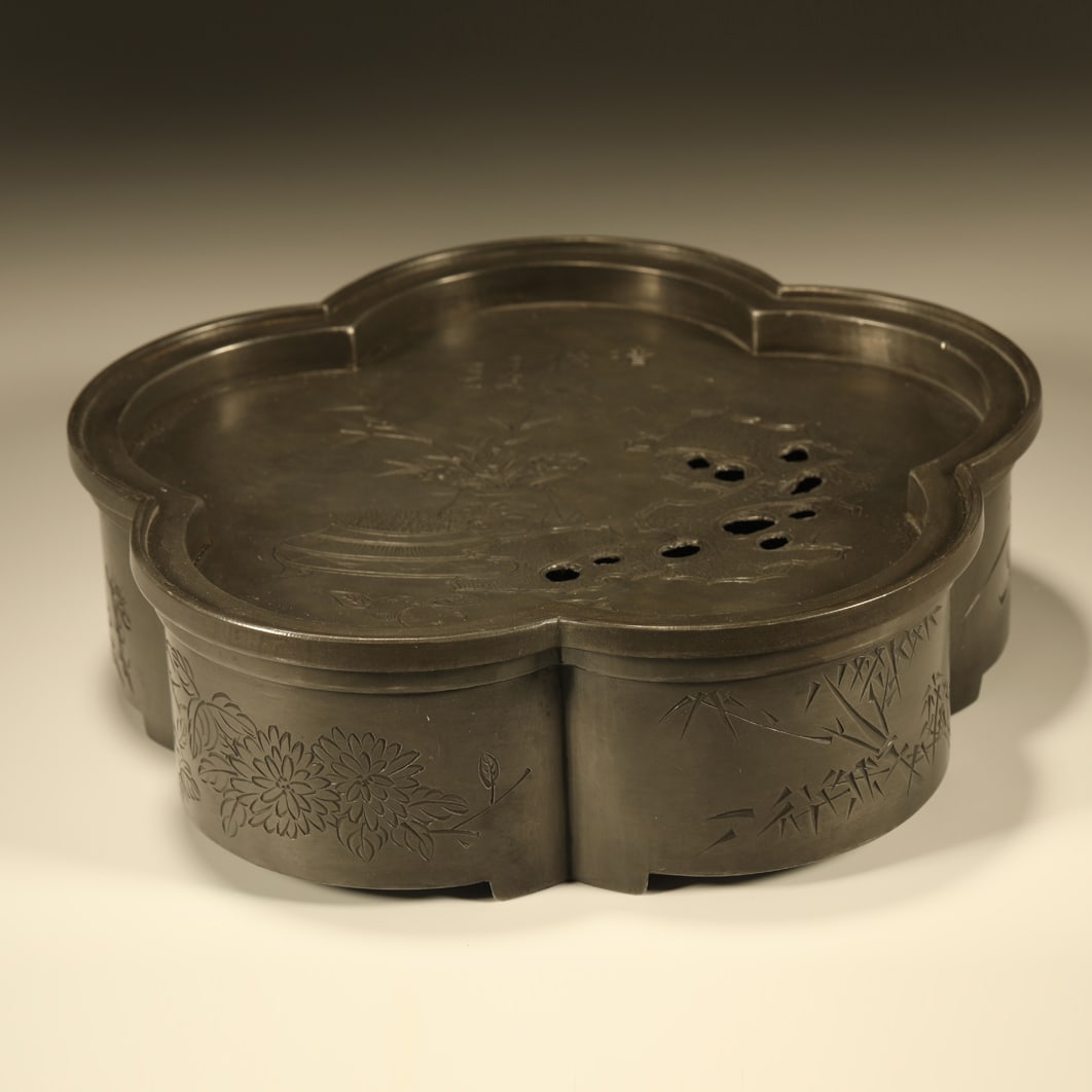 A TIN CARVED BEGONIA-SHAPED TEAPOT STAND WITH ANTIQUE MOTIFS: Tin Carved Begonia-shaped Teapot Stand with Antique Motifs