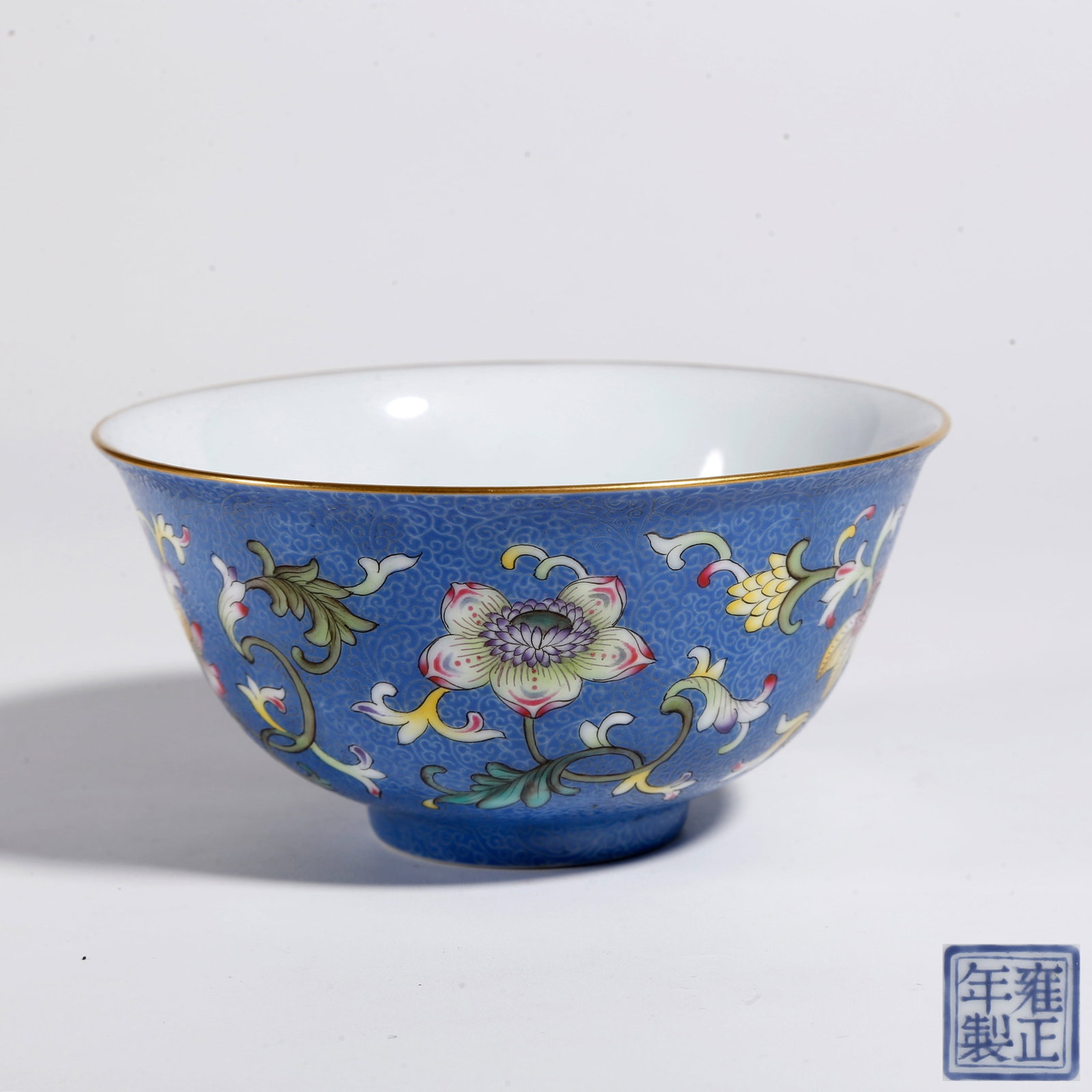 A BLUE GROUND ENGRAVED SCROLL FAMILLE ROSE FLORAL PATTERN BOWL: Blue Ground Engraved Scroll Famille Rose Floral Pattern Bowl
