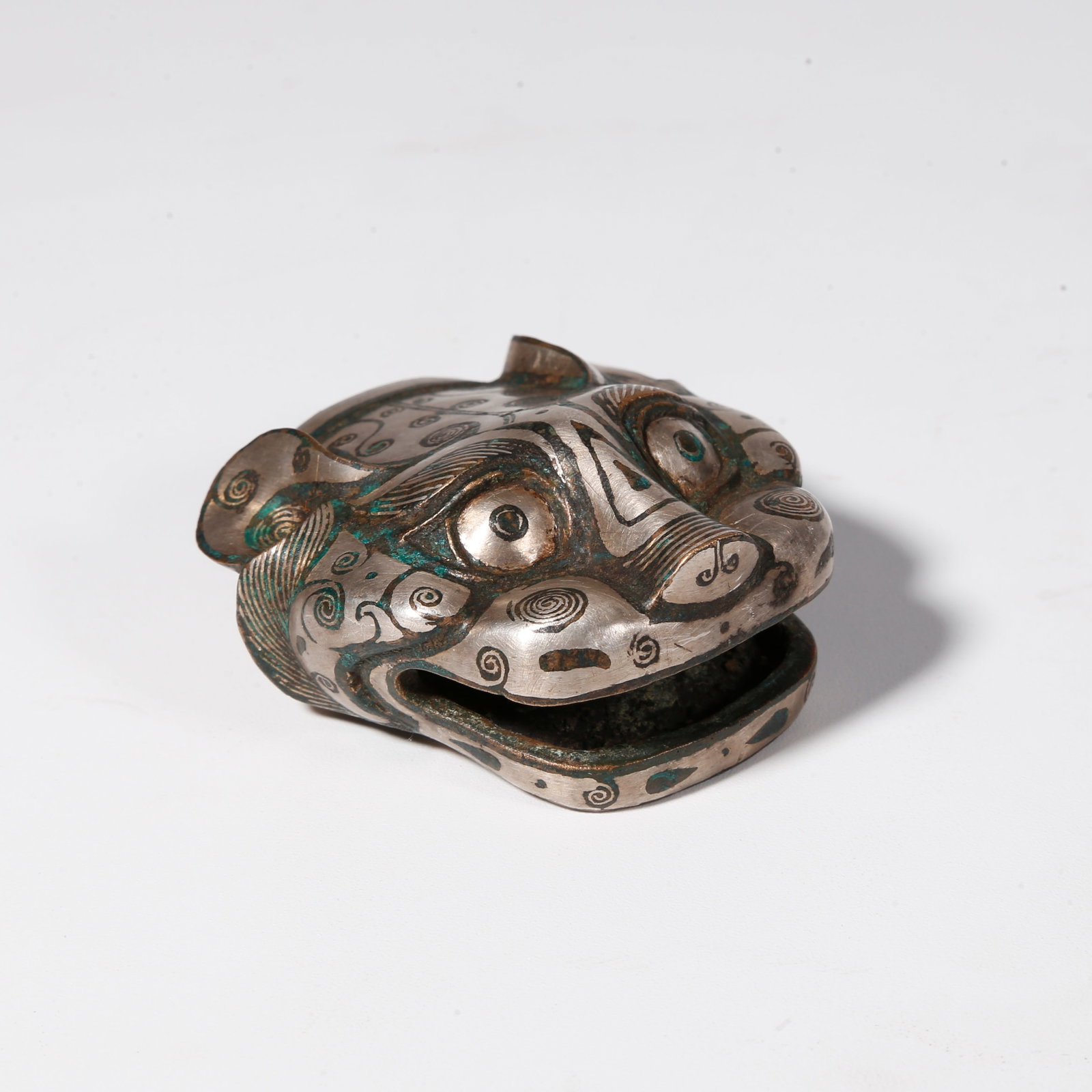 A BRONZE TIGER HEAD ORNAMENT WITH SILVER INLAY: Bronze Tiger Head Ornament with Silver Inlay