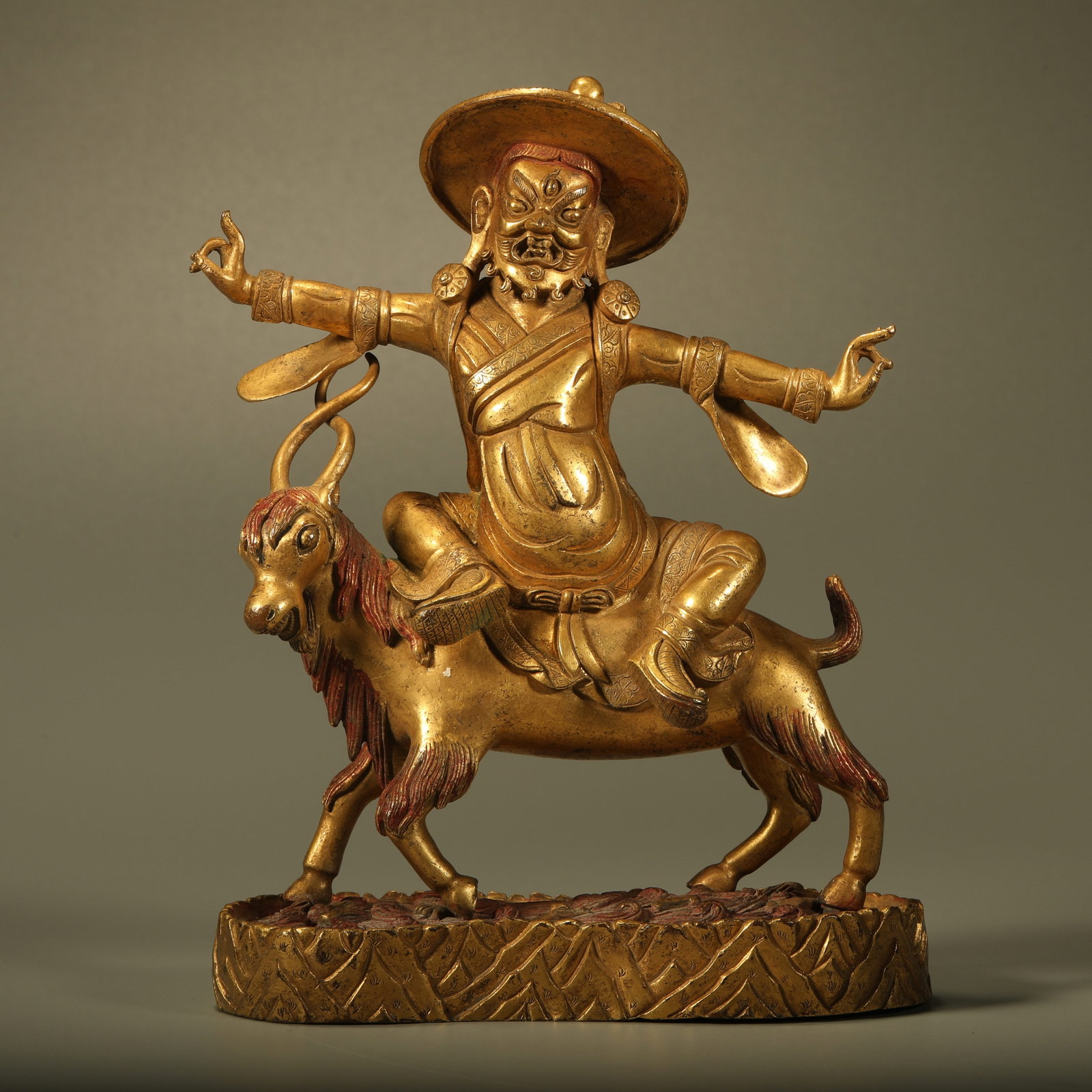 A GILT BRONZE STATUE OF DHARMA PROTECTOR RIDING SHEEP: Gilt Bronze Statue of Dharma Protector Riding Sheep