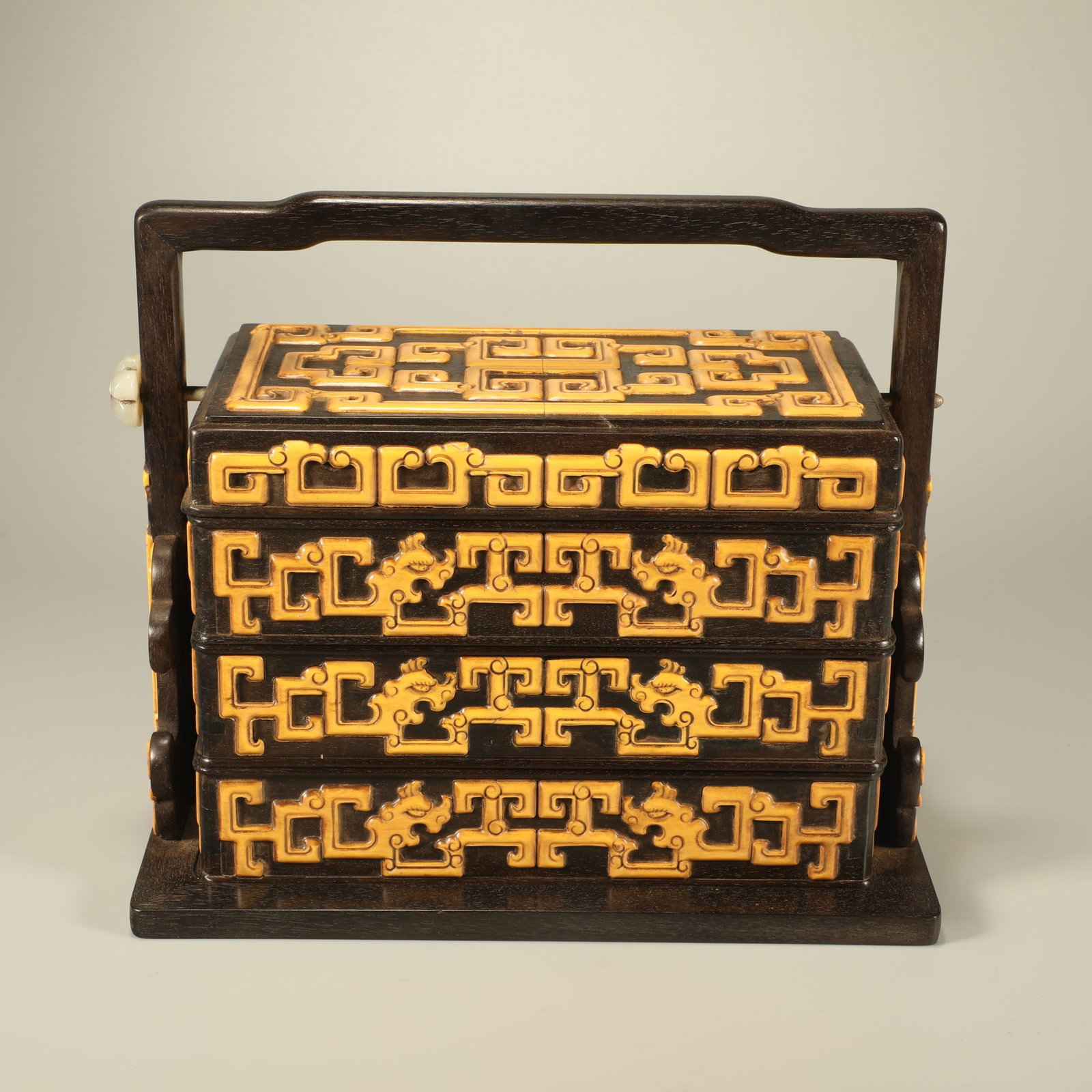 A ZITAN WOOD CARRY BOX CARVED WITH INTERLOCKING DRAGON SCROLLS: Zitan Wood Carry Box Carved with Interlocking Dragon Scrolls
