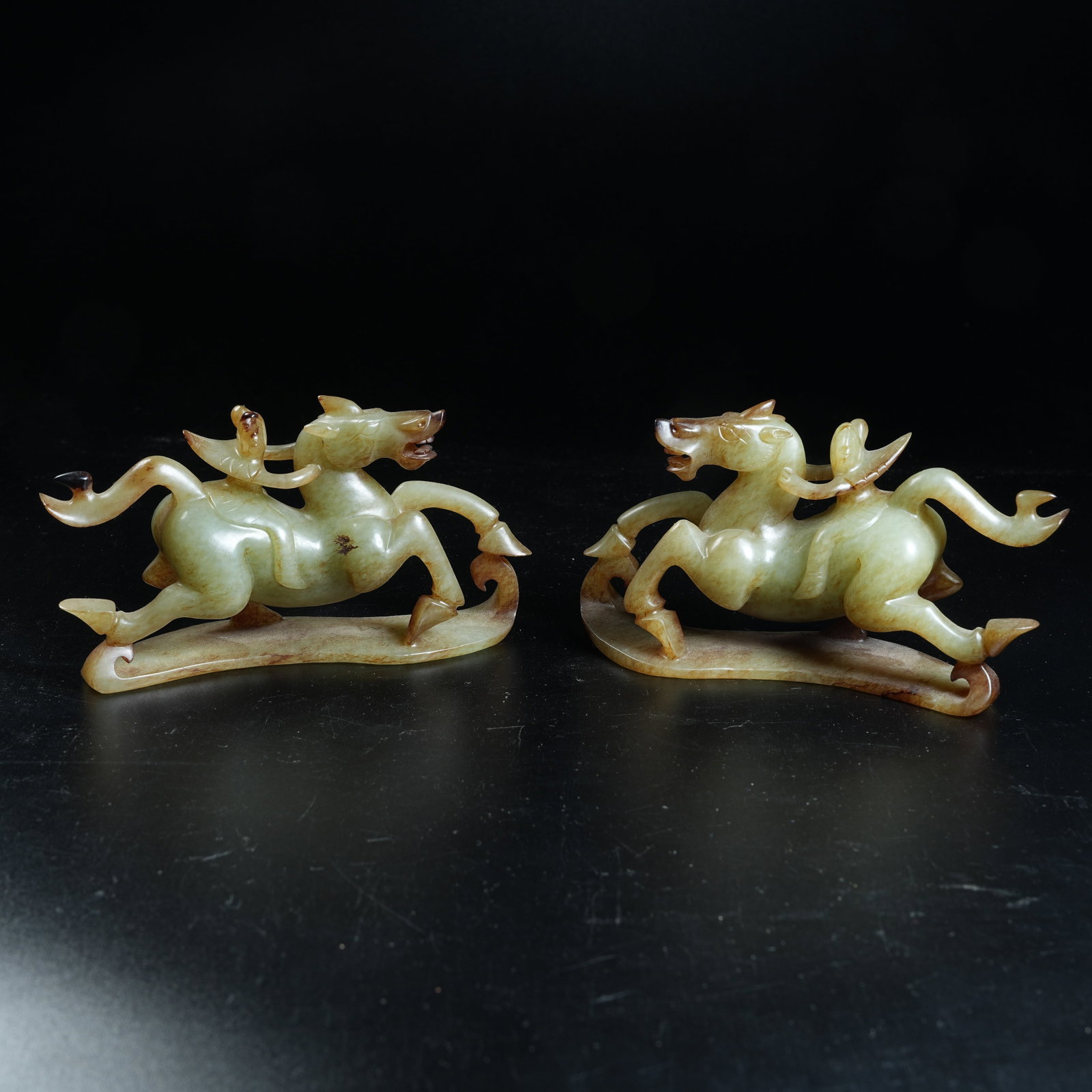 A SET OF ARCHAIC JADE ORNAMENTS OF WINGED IMMORTALS RESTING ON HORSES: Set of Archaic Jade Ornaments of Winged Immortals Resting on Horses