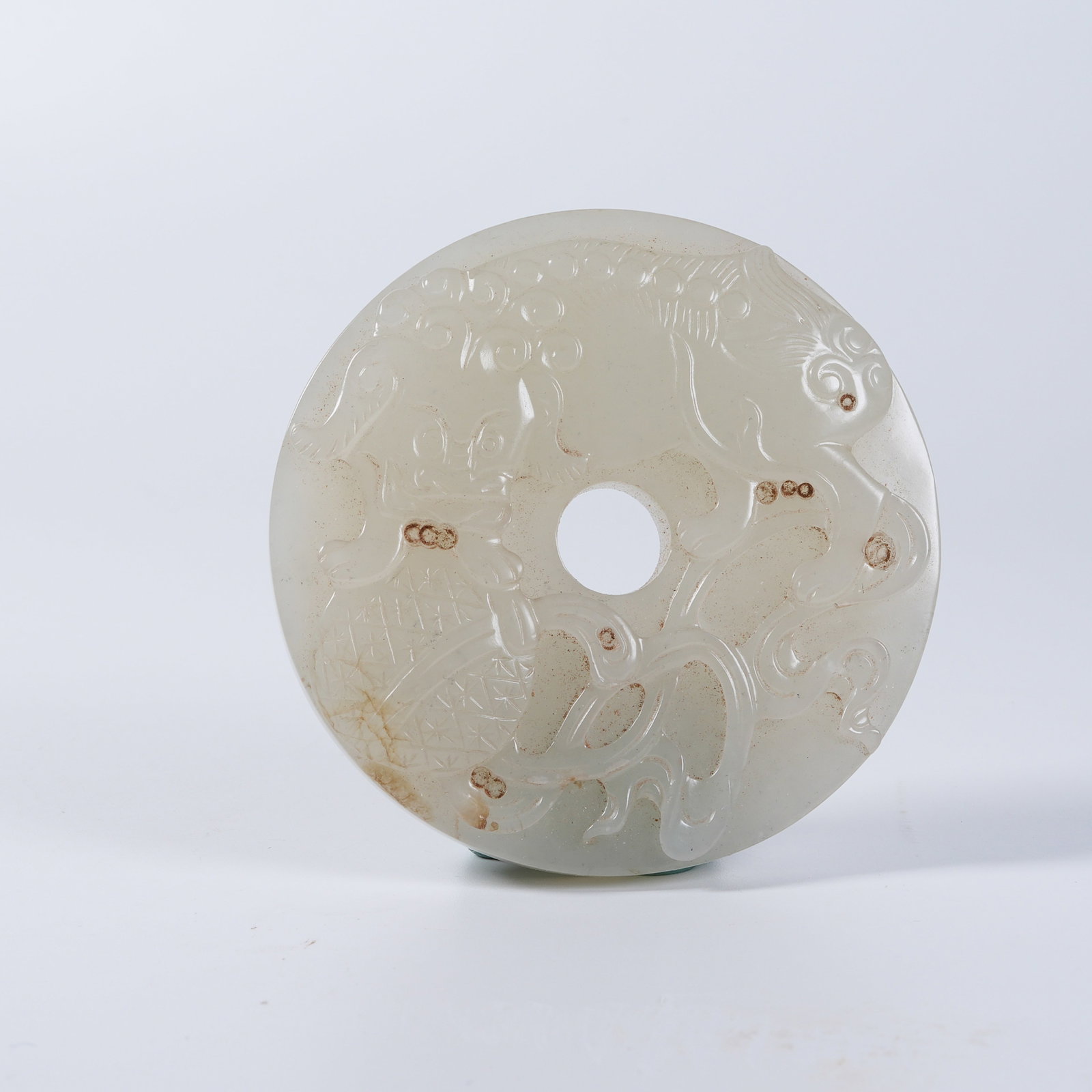 A HETIAN JADE BI-DISC WITH LION-ROLLING-EMBROIDERED-BALL PATTERN: Hetian jade bi-disc with lion-rolling-embroidered-ball pattern