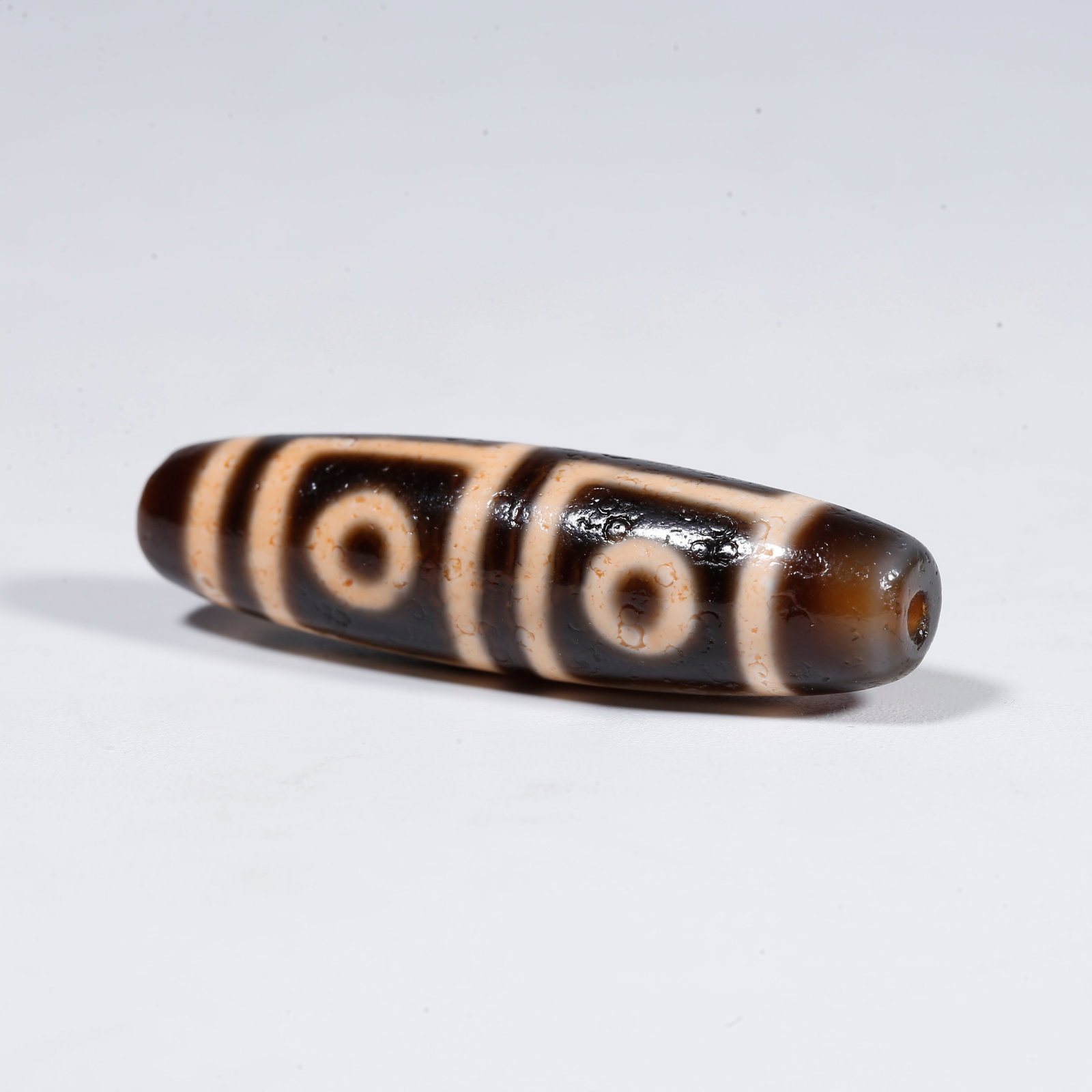 A FOUR-EYED DZI BEAD (1 of 9)