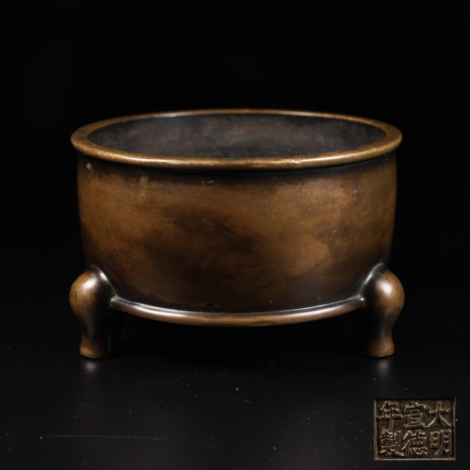 A BRONZE THREE-LEGGED TUBE-SHAPED CENSER: Bronze three-legged tube-shaped censer