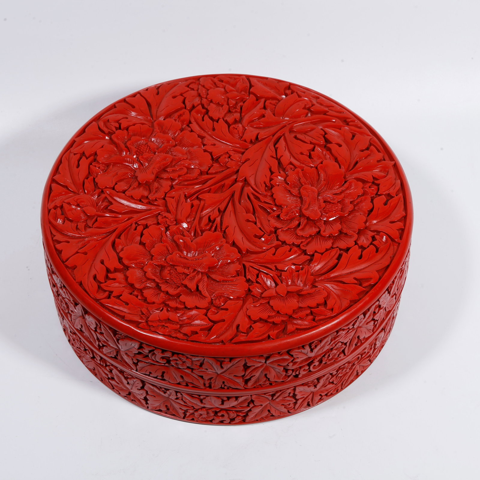A CARVED-RED HAND-HELD BOX WITH FLOWER PATTERN: Carved-red hand-held box with flower pattern