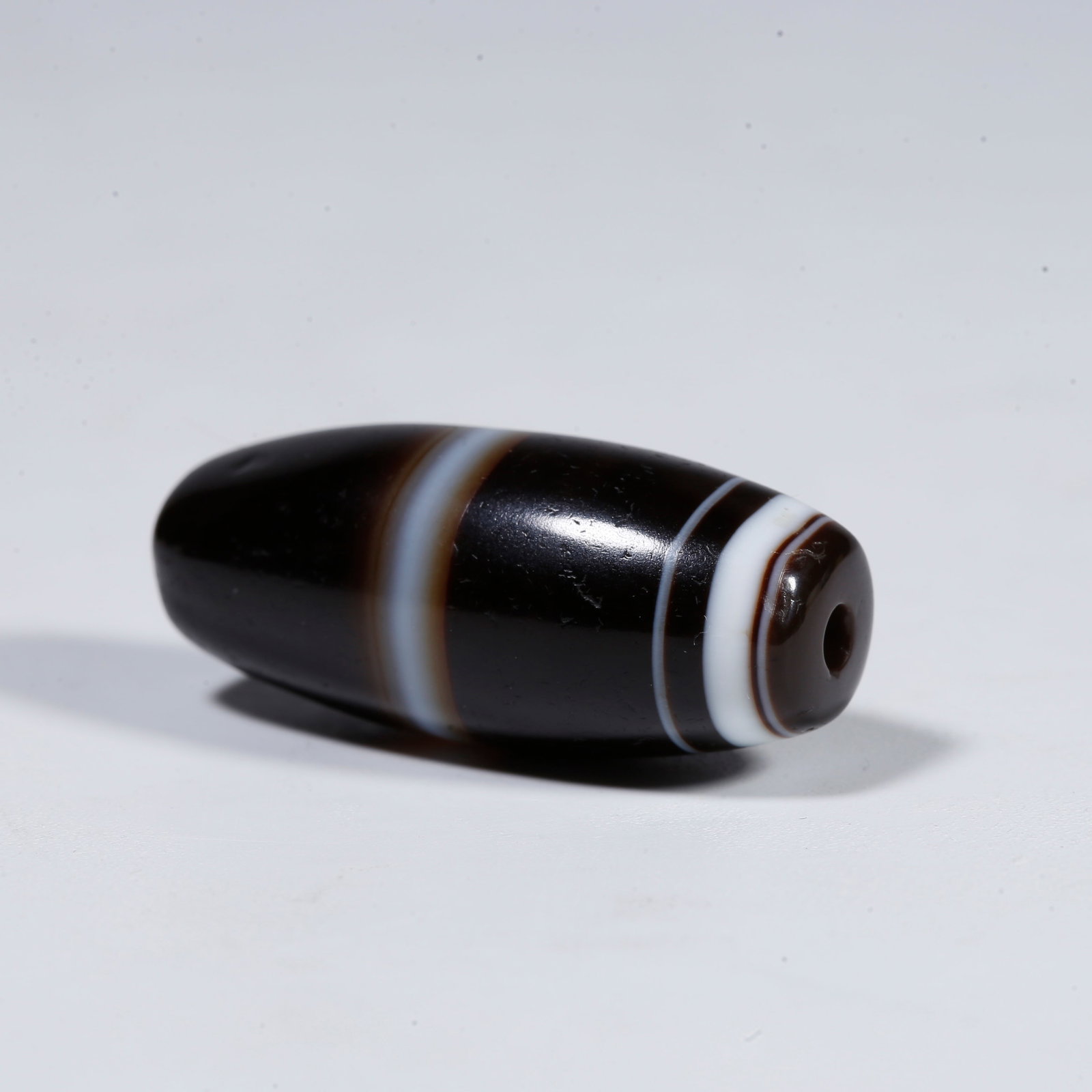 A SILK-BANDED AGATE DZI BEAD (1 of 8)