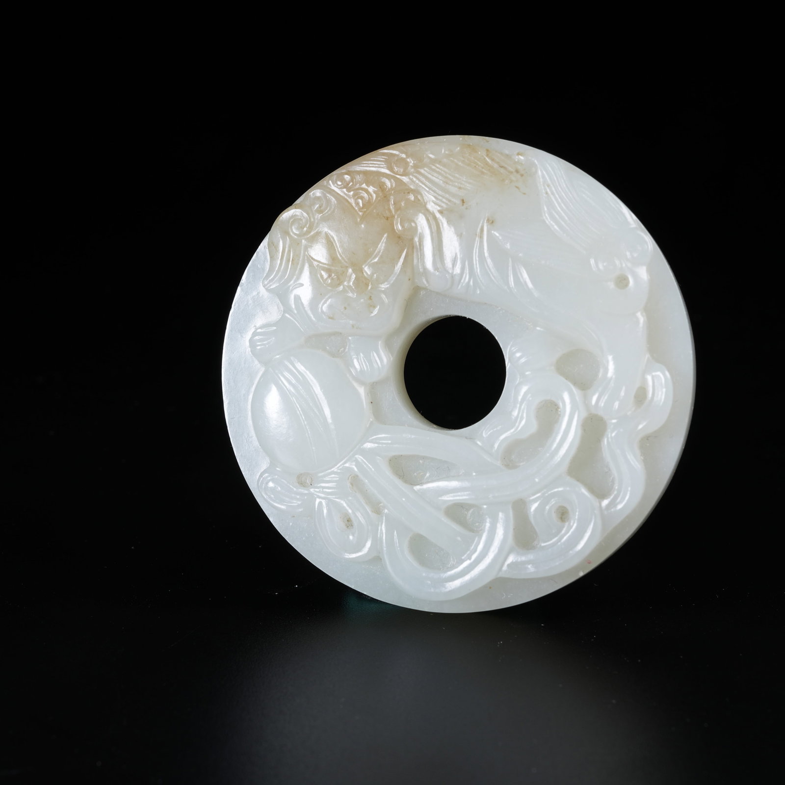 A HETIAN JADE BI DISC WITH LION ROLLING SILK BALL PATTERN: Hetian Jade Bi Disc with Lion Rolling Silk Ball Pattern