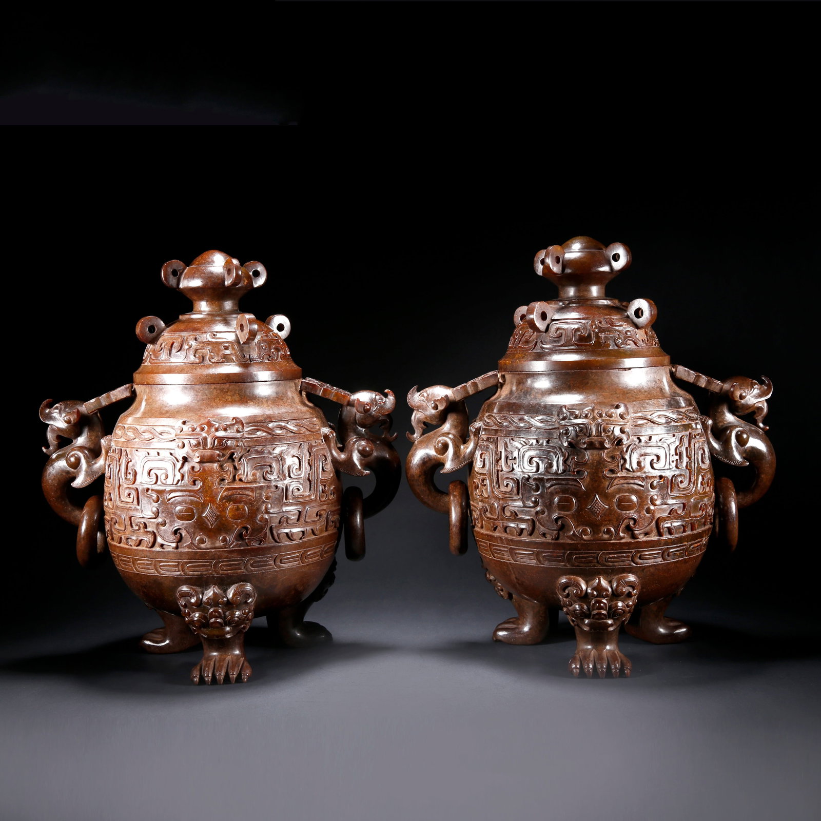 A PAIR OF ARCHAIC JADE THREE-LEGGED TWO-EARED LIDDED CENSERS CARVED WITH BEAST MASK PATTERN: Pair of Archaic Jade Three-Legged Two-Eared Lidded Censers Carved with Beast Mask Pattern