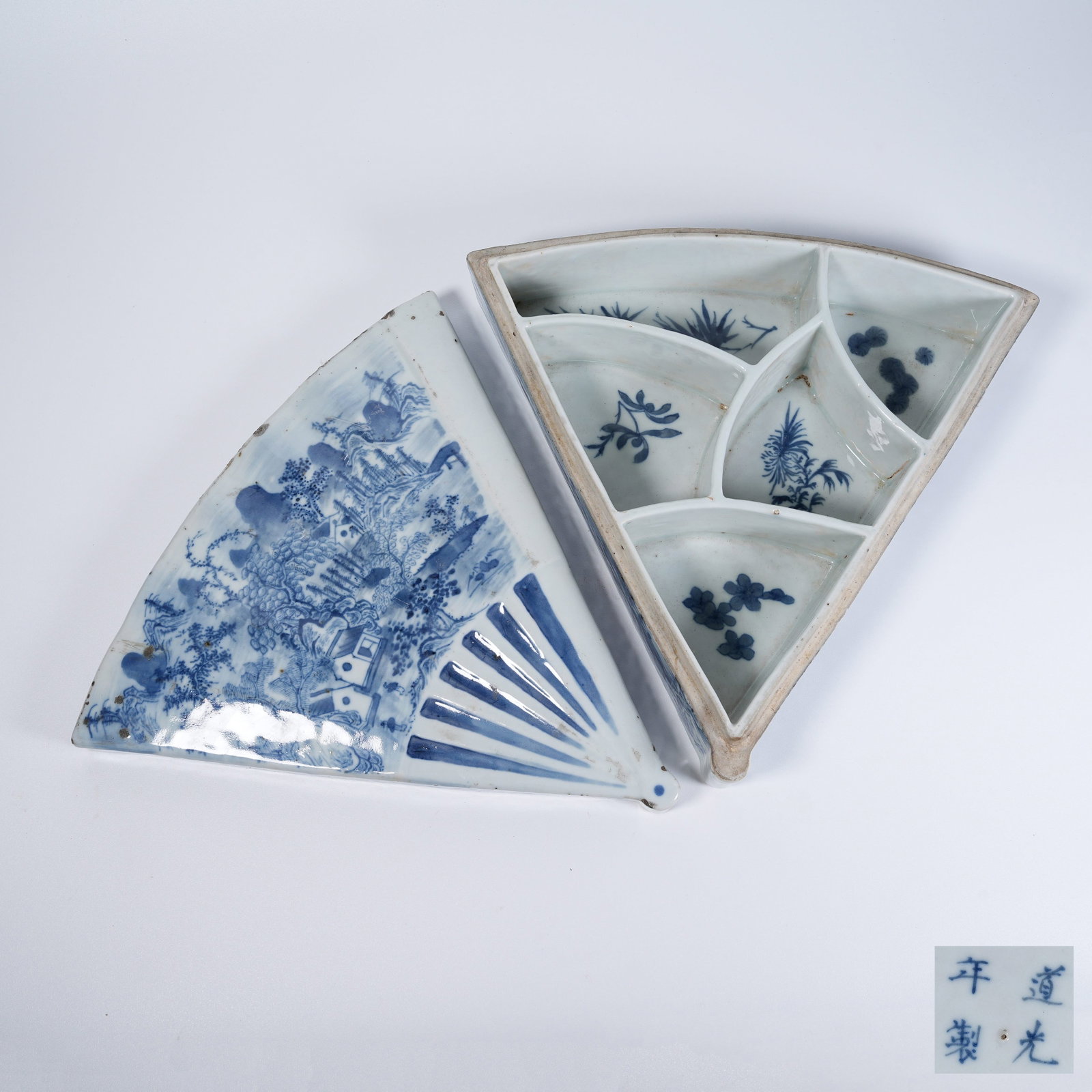 A FAN-SHAPED BLUE AND WHITE COVERED BOX WITH LANDSCAPE PATTERN: Fan-shaped blue and white covered box with landscape pattern