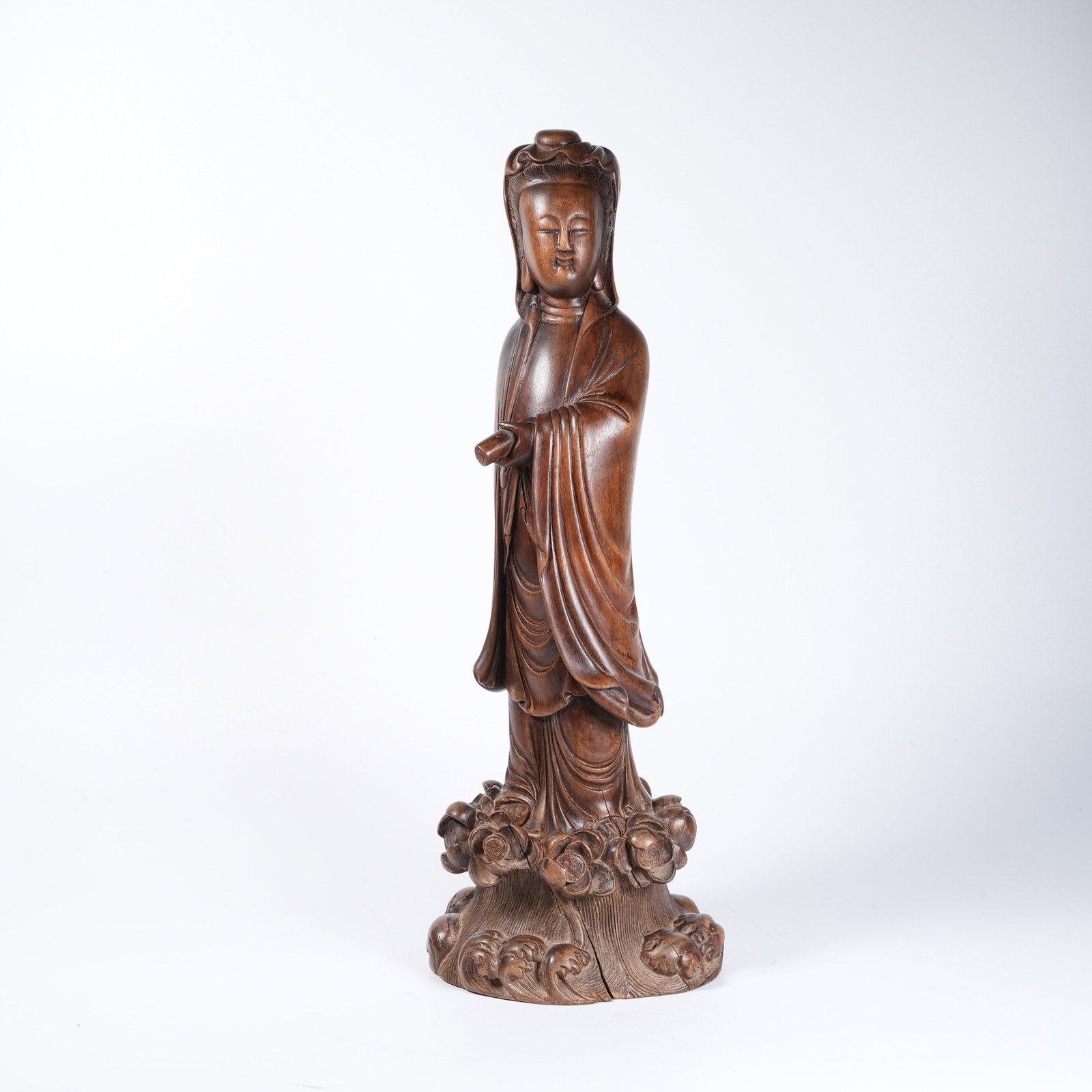A SANDALWOOD GUANYIN HOLDING SCROLL: Sandalwood Guanyin holding scroll