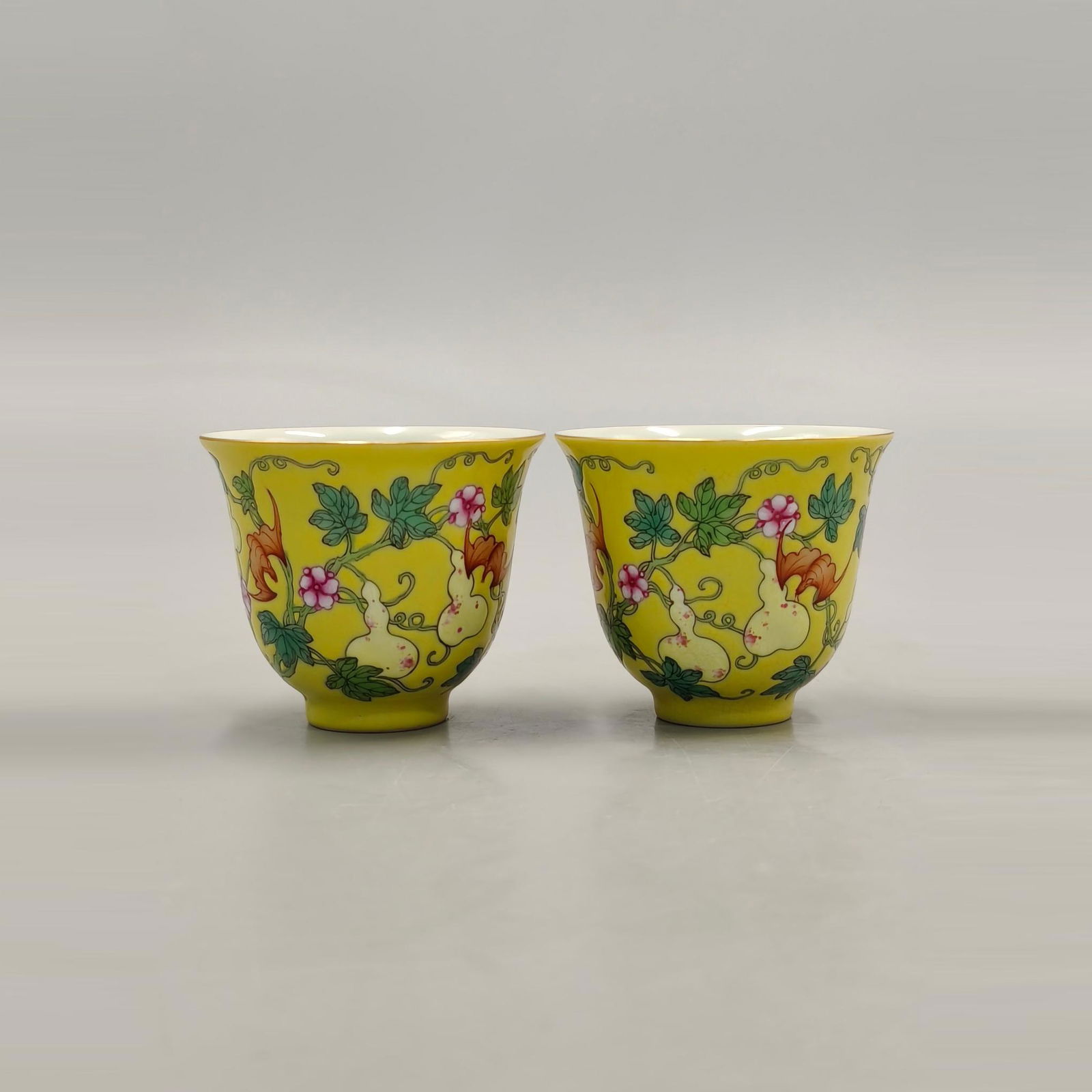 A PAIR OF PASTEL YELLOW GOURD PATTERN BELL CUPS: Height 6cm calibre 7cm
