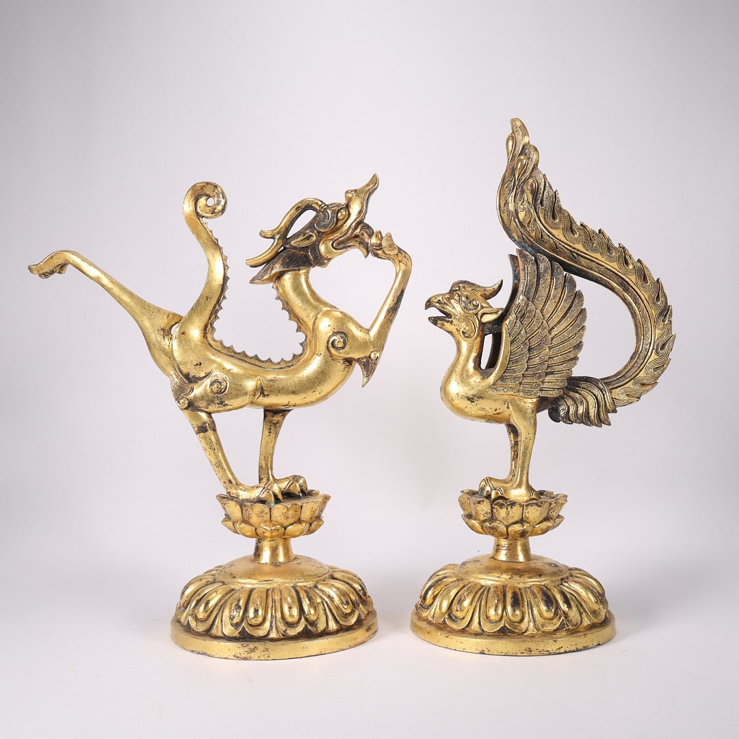 A PAIR OF GILT BRONZE DRAGON AND PHOENIX ORNAMENTS: Dragon: Length 17.3 cm, base diameter 9 cm, height 20.4 cm, weight 1120 g