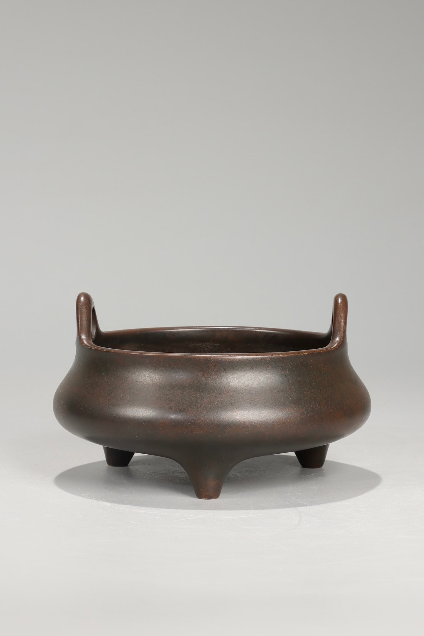 A QING DYNASTY QIANLONG PERIOD CENSER WITH UPWARD-POINTING EARS: It is 7.5cm high, has a mouth diameter of 11cm, and weighs 1020.5g.