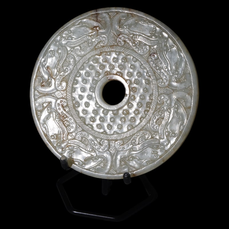 WHITE JADE BI DISC WITH ANIMAL FACE AND GRAIN PATTERN: 13.5 cm in diameter, 0.85 cm thick, weighing 305 grams.