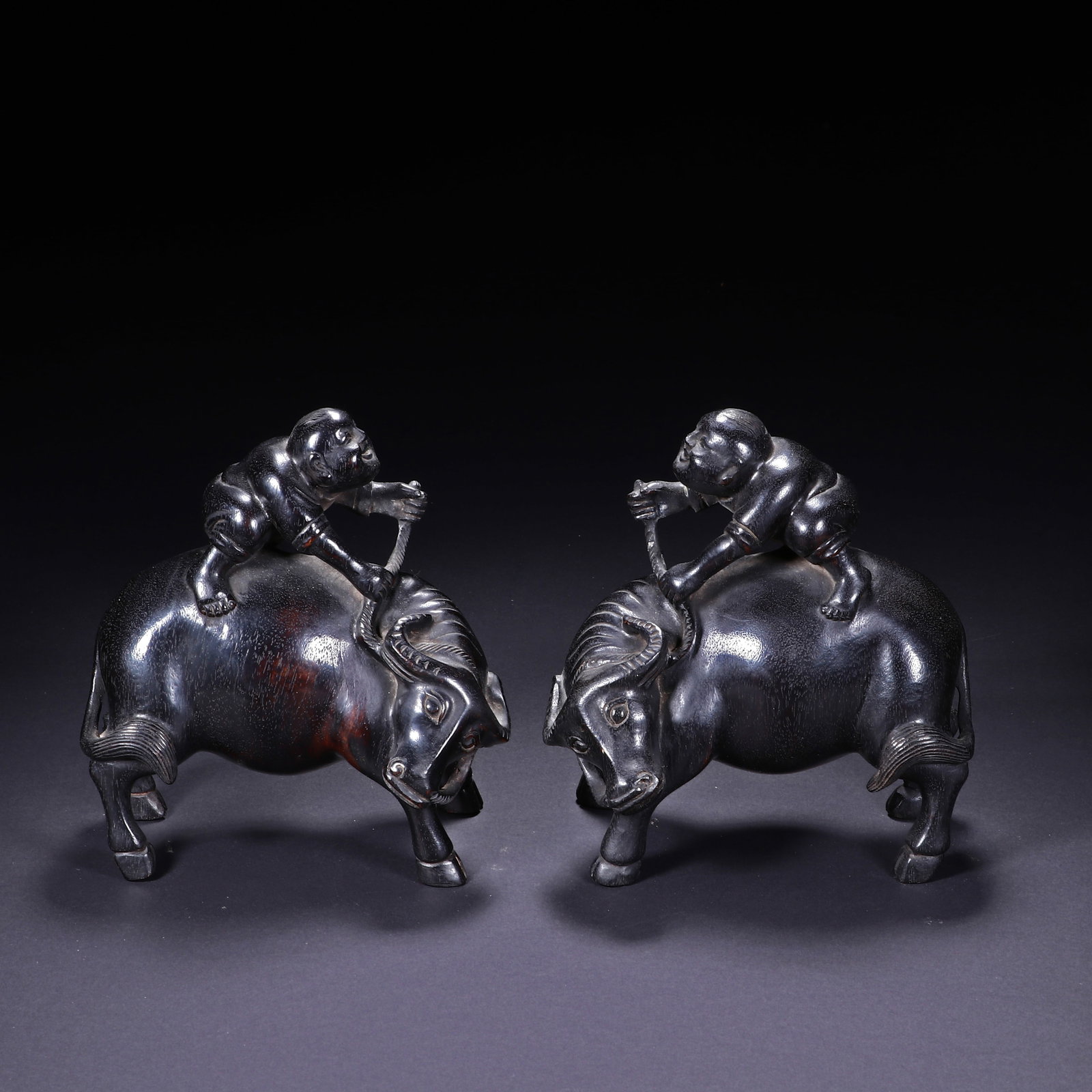 A PAIR OF SANDALWOOD FIGURINES OF CHILDREN PLAYING WITH OXEN: Height 12.7cm, Width 10.7cm