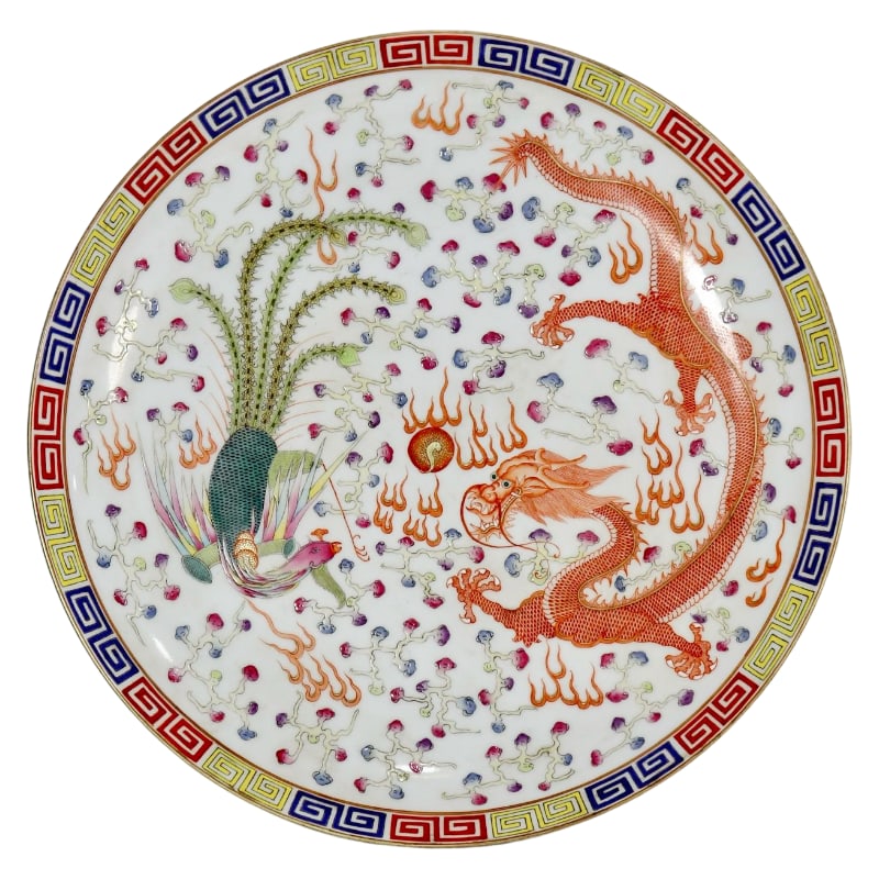 A LARGE PLATE WITH A FAMILLE ROSE DESIGN OF DRAGONS AND PHOENIXES PLAYING WITH A PEARL.: Diameter 47