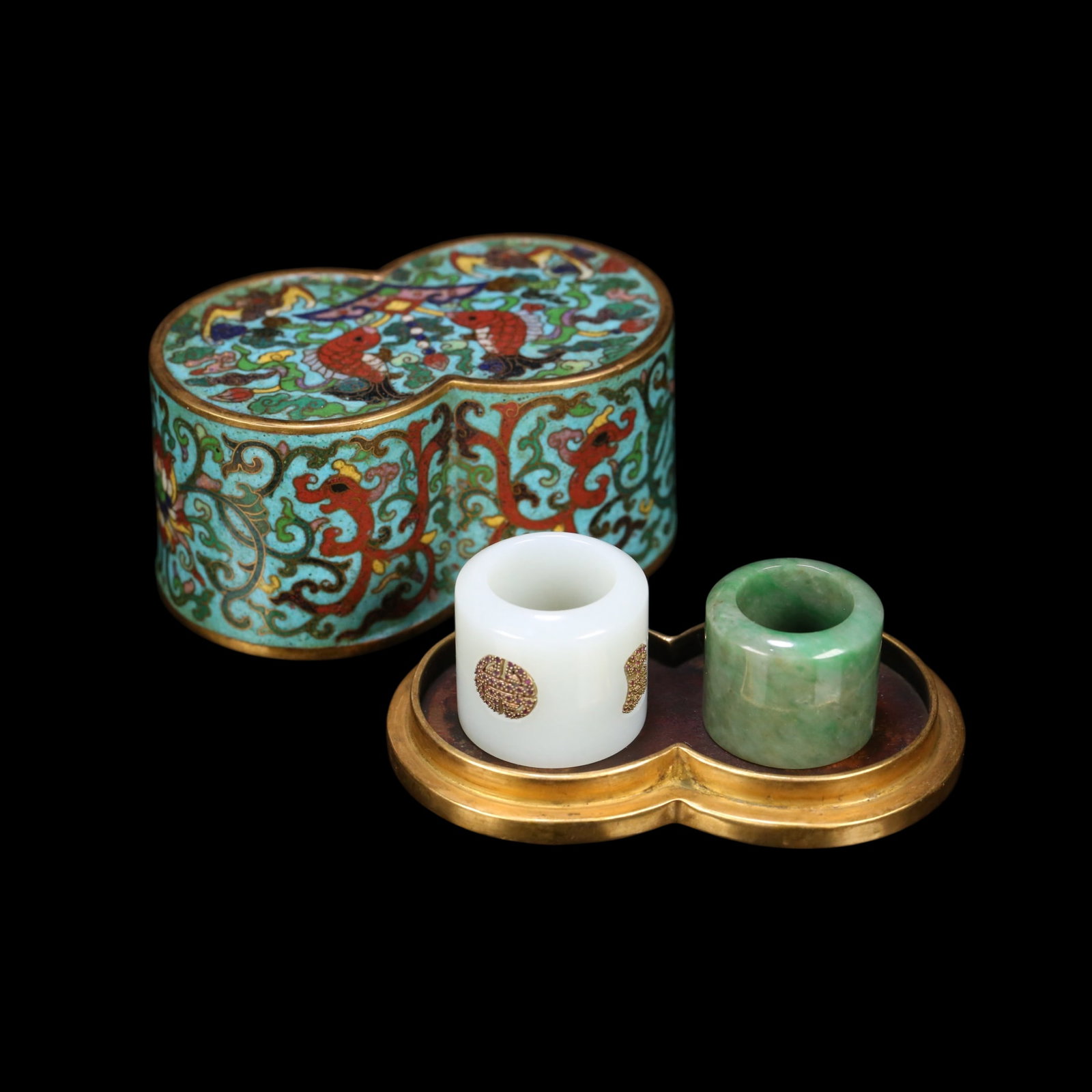 A SET OF QING DYNASTY CLOISONNÉ THUMB RINGS, JADE AND HETIAN JADE THUMB RINGS: The thumb ring box measures 10.2X6X5.4 cm and weighs 496.4 grams. The jade thumb ring has an inner diameter of 2.2 cm, a height of 3 cm, and weighs 40.5 grams. The jadeite thumb ring has an inner