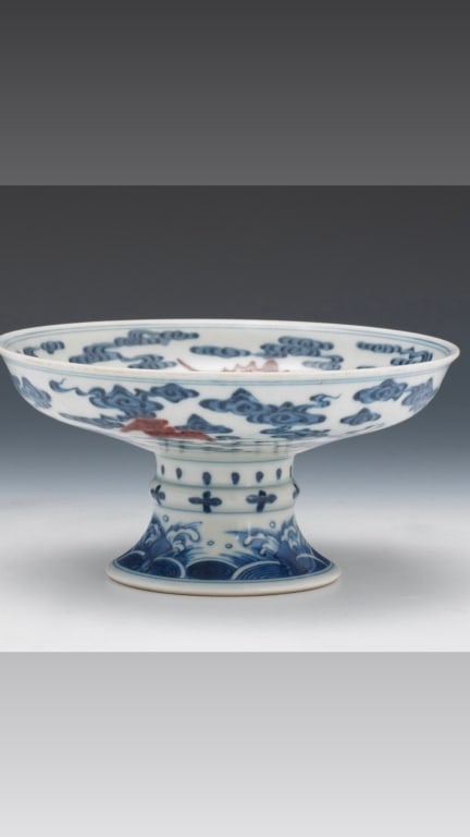 Chinese Porcelain Blue and Copper Red Footed Dishk Porcelain bowl with slightly flared rim with: Porcelain bowl with slightly flared rim with double underglaze blue circles around; raised on baluster stem and tapered foot. Hand enameled in underglaze blue and copper-red depicting awabi bats flyin