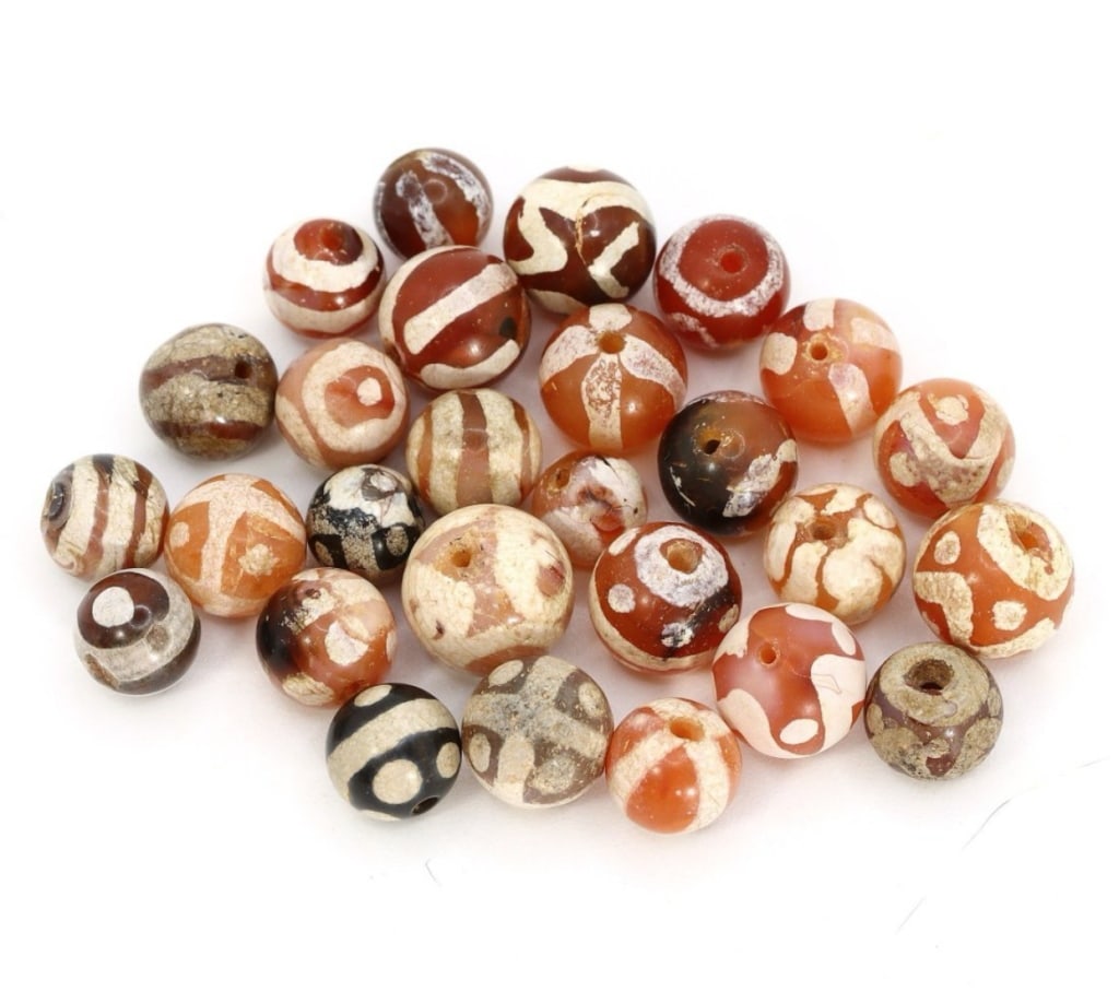 Group of 27 Medieval Himalayan Silk Road Tibetan Group of 27 Medieval Himalayan Silk Road Tibetan: Group of 27 Medieval Himalayan Silk Road Tibetan Etched Carnelian Dzi Beads (6th-17th Century AD)These remarkable Tibetan etched carnelian dzi beads, totaling 27 in number, offer a captivating glimpse