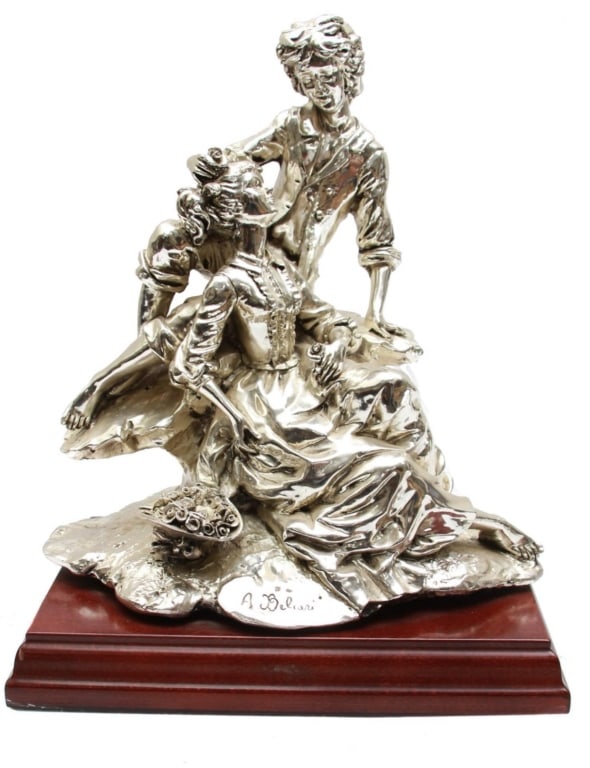 A vintage Italian Capodimonte-style silver-plated figurine of lovers, signed: A.Beliori. Mounted: A vintage Italian Capodimonte-style silver-plated. A vintage Italian Capodimonte-style silver-plated figurine of lovers, signed: A.Beliori. Mounted on a rectangular wooden base.Dimensions: L: 10 in.W: