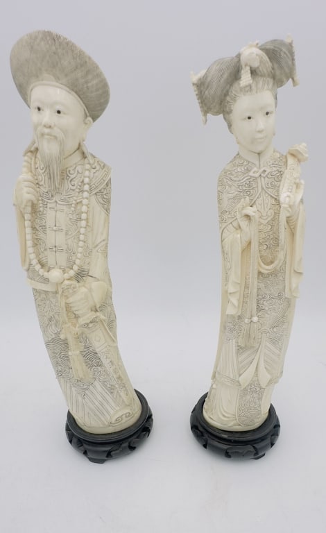 Pair Of Majestic Antique hard carving ivory elephant tusk Chinese Emperor And Empires: Pair Of Majestic Antique Chinese Emperor And Empress figures, depicting a dignitary and a lady in court attire. Each figure is meticulously detailed, with elaborate patterns to the robes, headdresses,