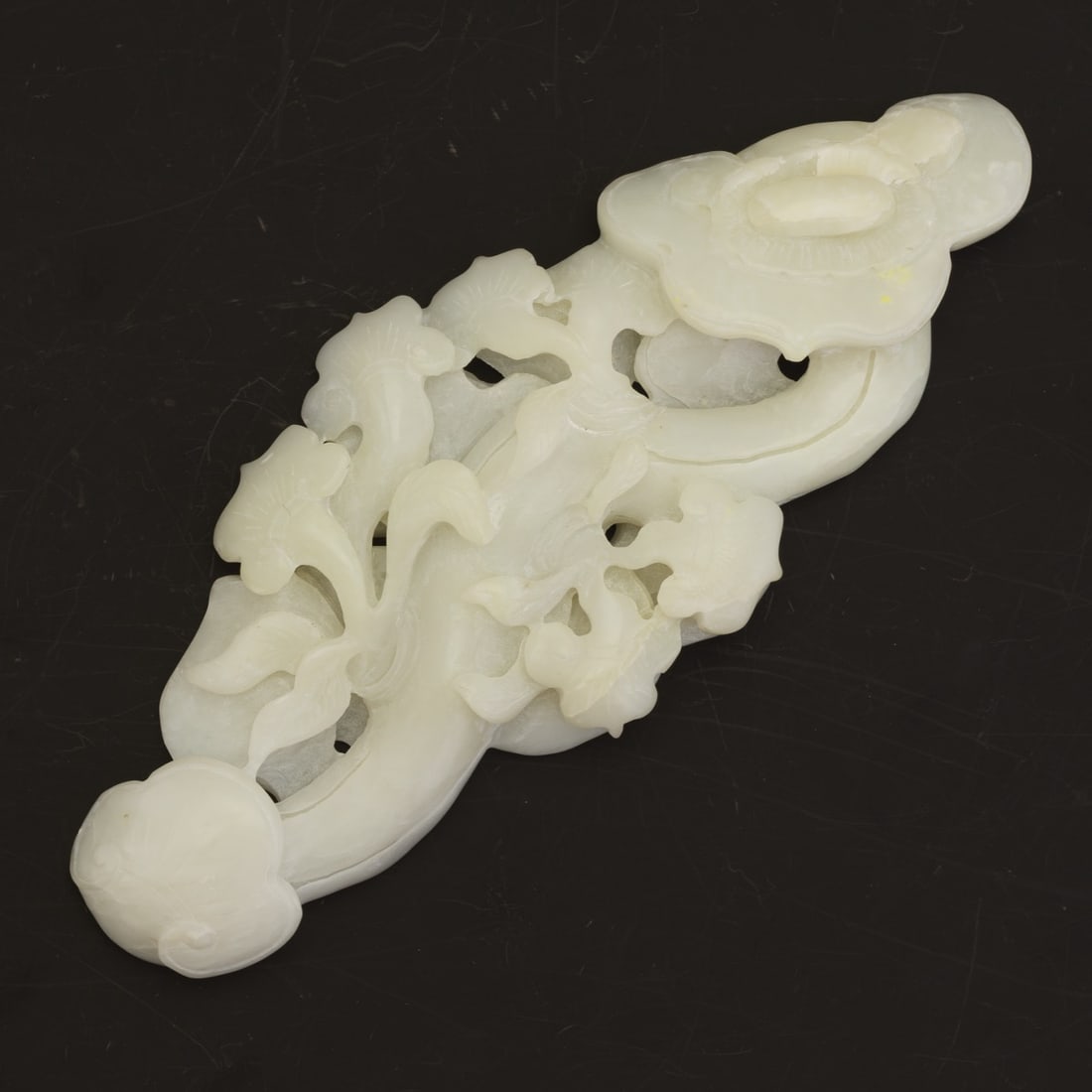19TH large Chinese Carved Jade QING Dynasty Chinese Carved White Jade Belt Hook with Lingzhi and: Chinese Carved White Jade Belt Hook with Lingzhi and Lotus MotifAn intricately carved Chinese white jade belt hook, featuring elegant openwork designs of lingzhi fungus and lotus blossoms, symbolizing