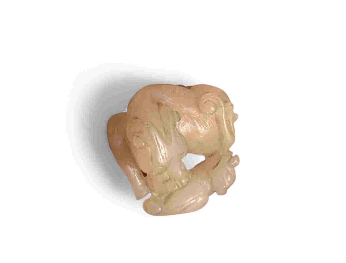 19th qilin jade holding accompanied by another 19th qilin A finely carved Chinese pale celadon jade: 19th qilin A finely carved Chinese pale celadon jade toggle, depicting two intertwined figures/creatures in a playful pose. The stone is of an even tone with slight russet inclusions, softly polished