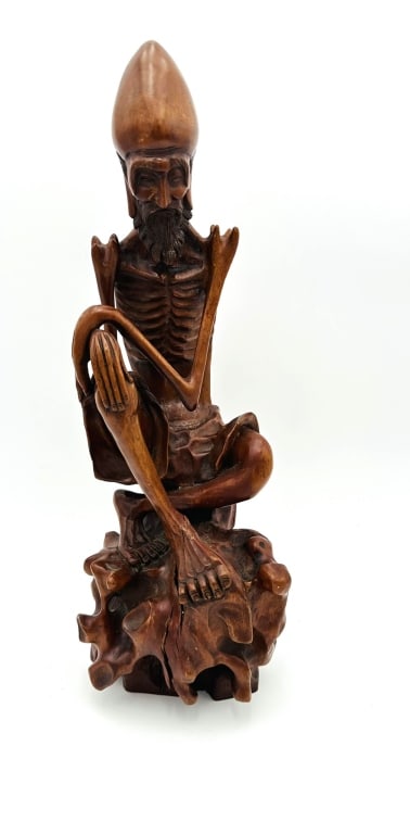 A Large chinese Carved Boxwood Hand-Carved Wooden Sculpture of an Ascetic Monk or LohanFinely carved: Hand-Carved Wooden Sculpture of an Ascetic Monk or LohanFinely carved wooden figure of a seated ascetic, portrayed in emaciated form with pronounced ribs, beard, and exaggerated head. The figure is se