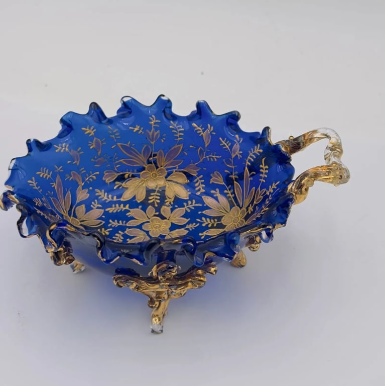 Bohemian Moser Cobalt Blue Gilt Glass Footed Bowl with Handle: An elegant Bohemian glass bowl attributed to Moser, finely executed in deep cobalt blue glass. The bowl features a scalloped rim and is richly decorated with hand-painted gilt floral and foliate motif