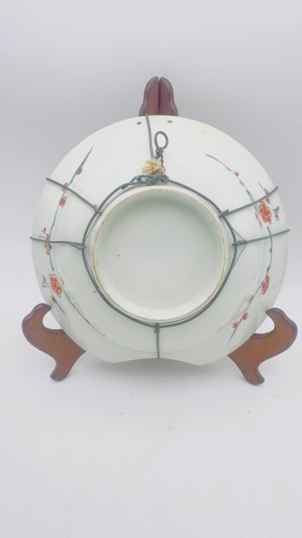 A finely decorated Japanese Imari porcelain charger, featuring a vibrant polychrome 1760s: A finely decorated Japanese Imari porcelain charger, featuring a vibrant polychrome palette of iron-red, cobalt blue, and green enamels. The central medallion is adorned with stylized floral motifs fr