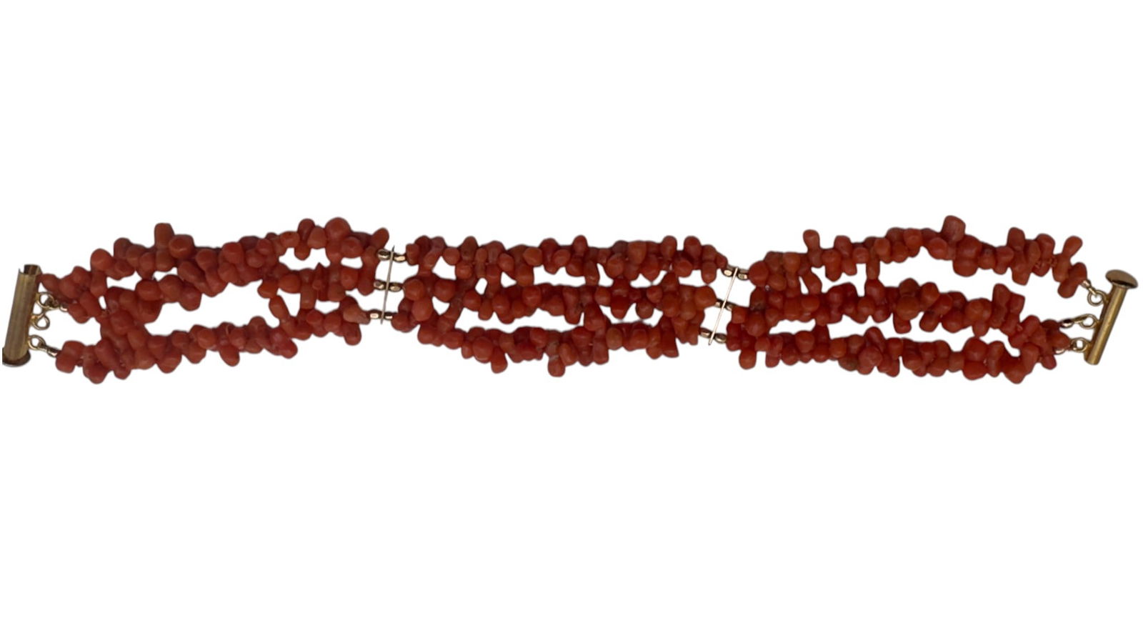 A vintage bracelet composed of three strands of irregular natural coral chip beads joined by metal: A vintage bracelet composed of three strands of irregular natural coral chip beads joined by metal spacer bars and fitted with a bar clasp. The coral displays natural color variation typical of Medite