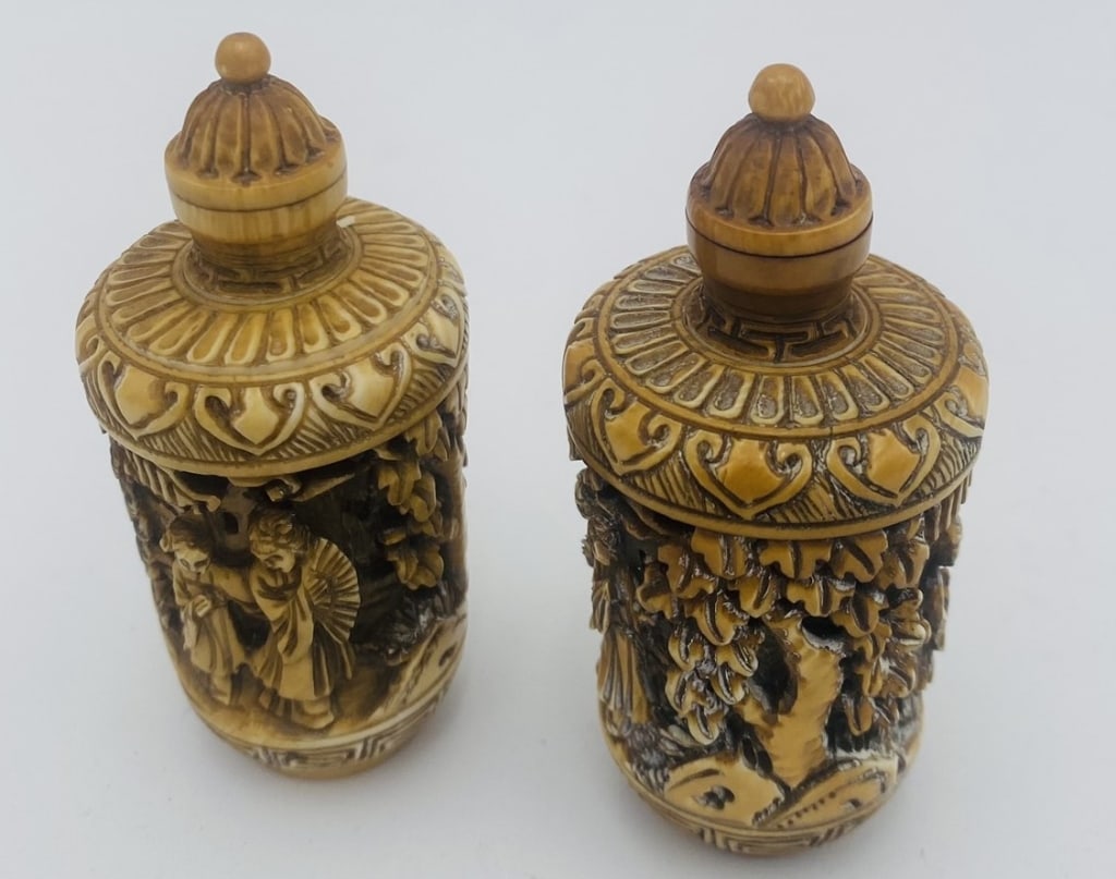 19 th Pair of Chinese snuff / Faux Ivory Carved Covered Jars,: A finely carved pair of Chinese-style snuff bottles in the form of traditional snuff bottles, each intricately decorated in relief with detailed figural and landscape scenes. The bodies feature openwo