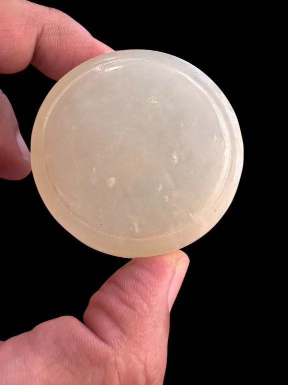 Chinese Carved Nephrite Jade Circular Box with LidA finely carved circular box crafted from a: Chinese Carved Nephrite Jade Circular Box with LidA finely carved circular box crafted from a single piece of creamy-white nephrite jade. The box features a smooth, polished surface with natural inclu