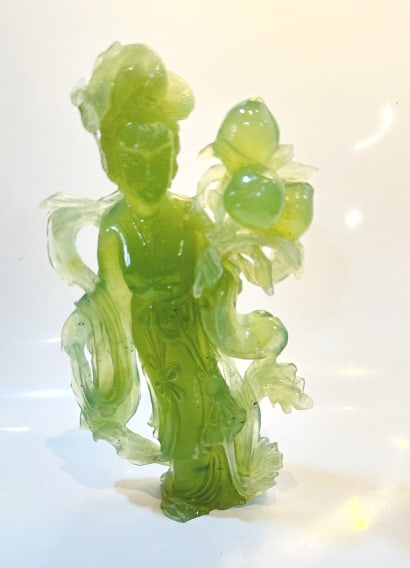 Carved Jade Figurine of a Chinese Maiden Holding Peonies An elegant Chinese figurine finely carved: Carved Jade Figurine of a Chinese Maiden Holding Peonies An elegant Chinese figurine finely carved from translucent green jade, depicting a serene maiden or Guanyin (Goddess of Mercy).