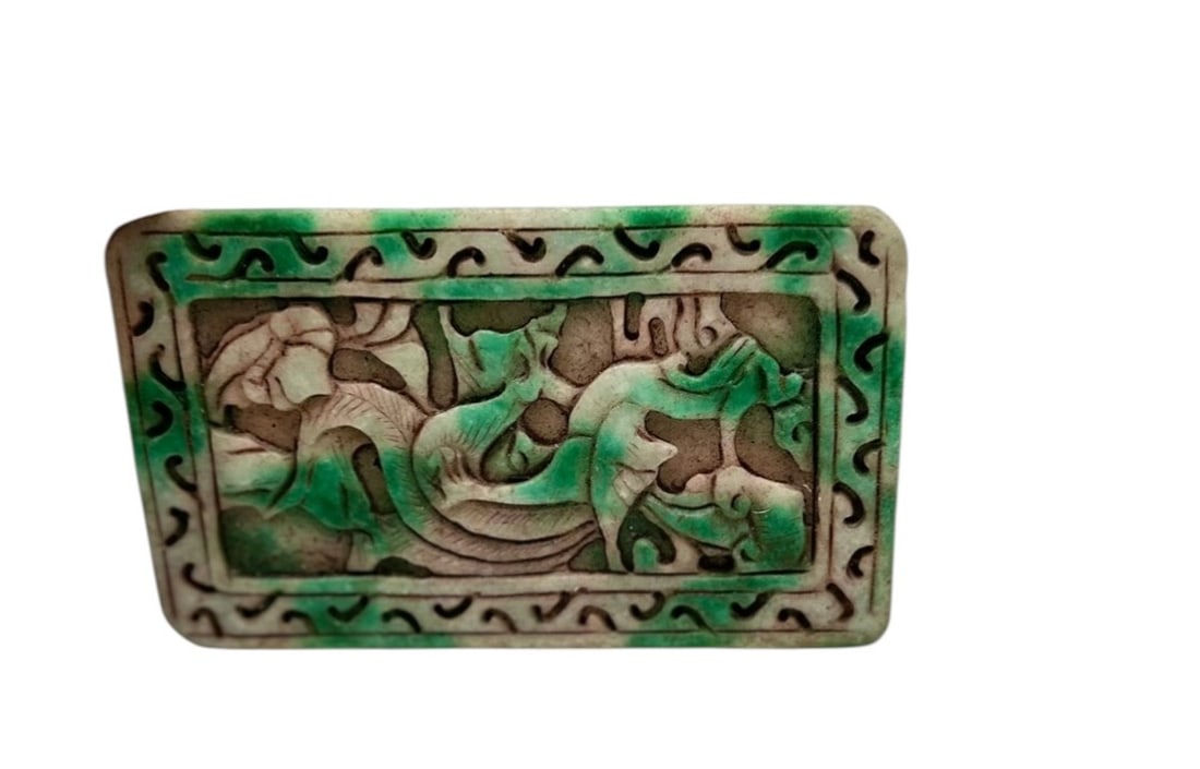 Chinese Carved Jade Openwork Plaque with Dragon MotifRectangular carved jade plaque featuring an: Chinese Carved Jade Openwork Plaque with Dragon MotifRectangular carved jade plaque featuring an openwork design of a sinuous dragon amid stylized cloud and scrolling motifs. The plaque is framed with