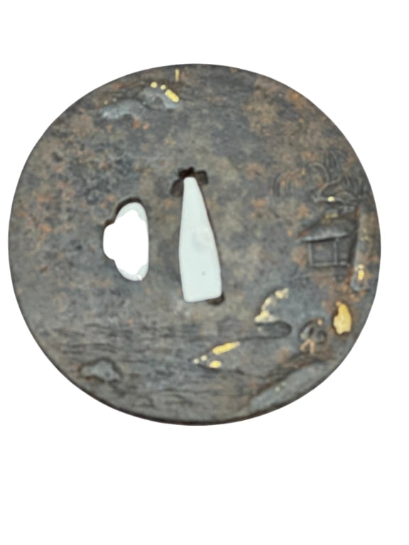 Japanese Iron Tsuba with Landscape SceneRound iron sword guard (tsuba) decorated in low relief: Japanese Iron Tsuba with Landscape SceneRound iron sword guard (tsuba) decorated in low relief with a landscape scene featuring a pine tree, shoreline, and architectural elements including a lantern a