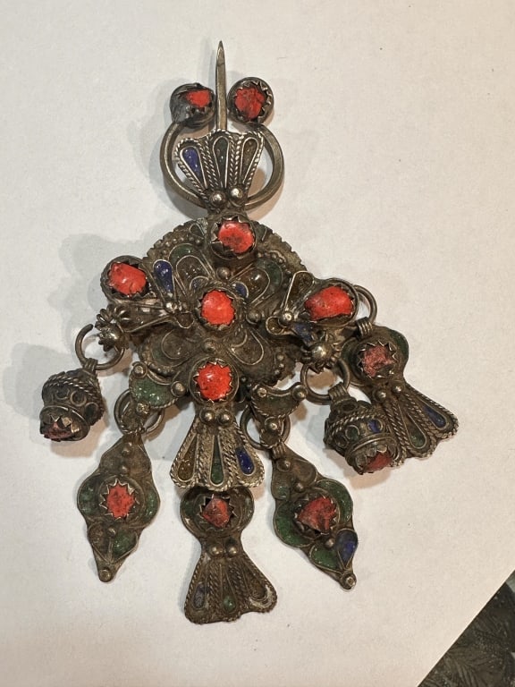 A beautiful handcrafted Moroccan silver fibula (brooch) richly decorated with coral cabochons and: A beautiful handcrafted Moroccan silver fibula (brooch) richly decorated with coral cabochons and colorful enamel work in tones of blue and green. The design features