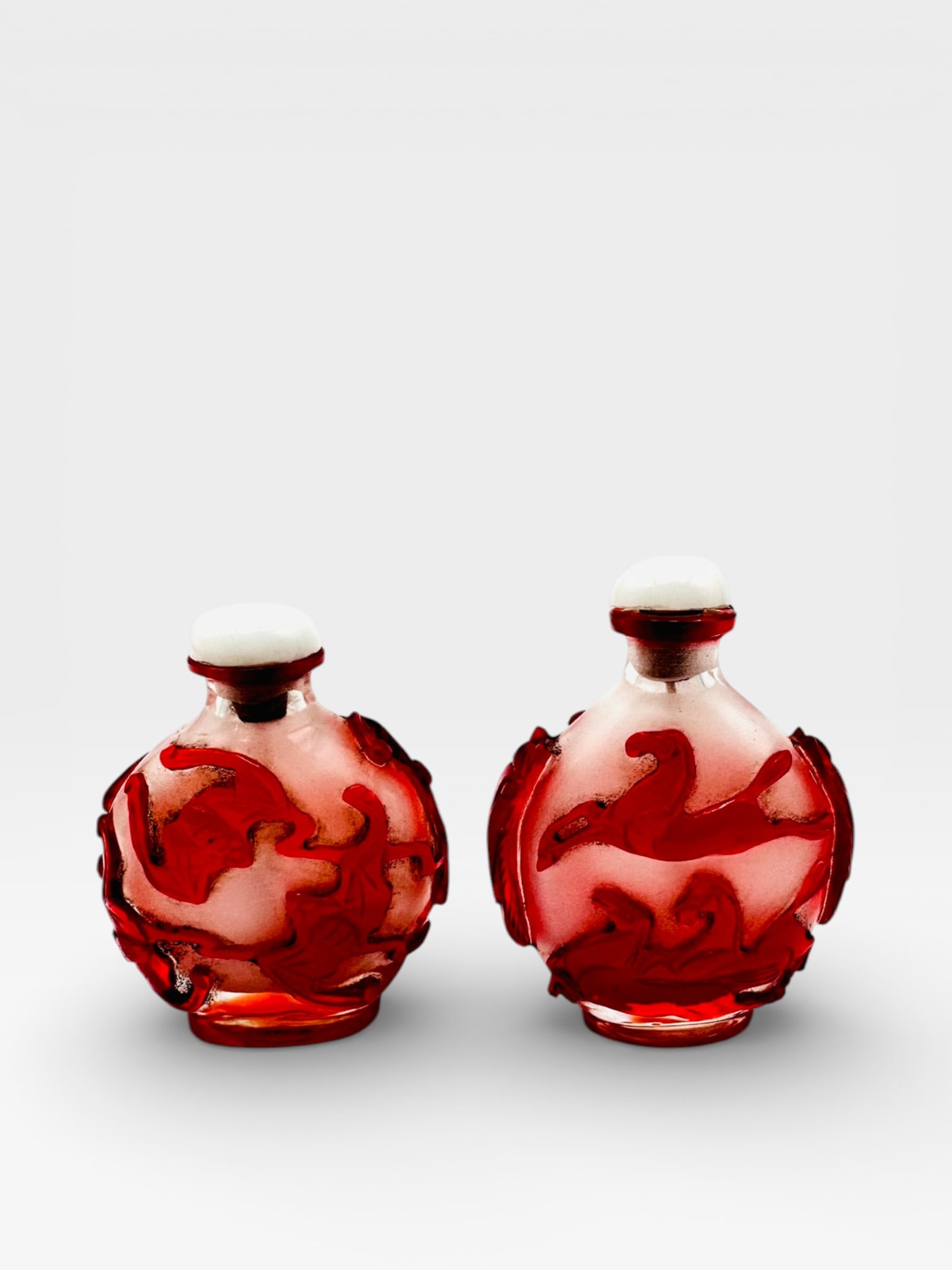 A decorative pair of art glass perfume bottles, each of spherical form, executed in red and (1 of 4)