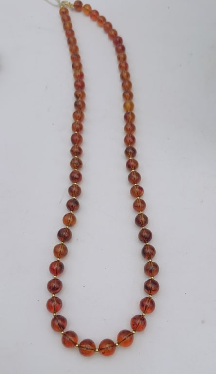 A refined necklace composed of polished round amber beads in warm cognac and honey tones, strung (1 of 4)