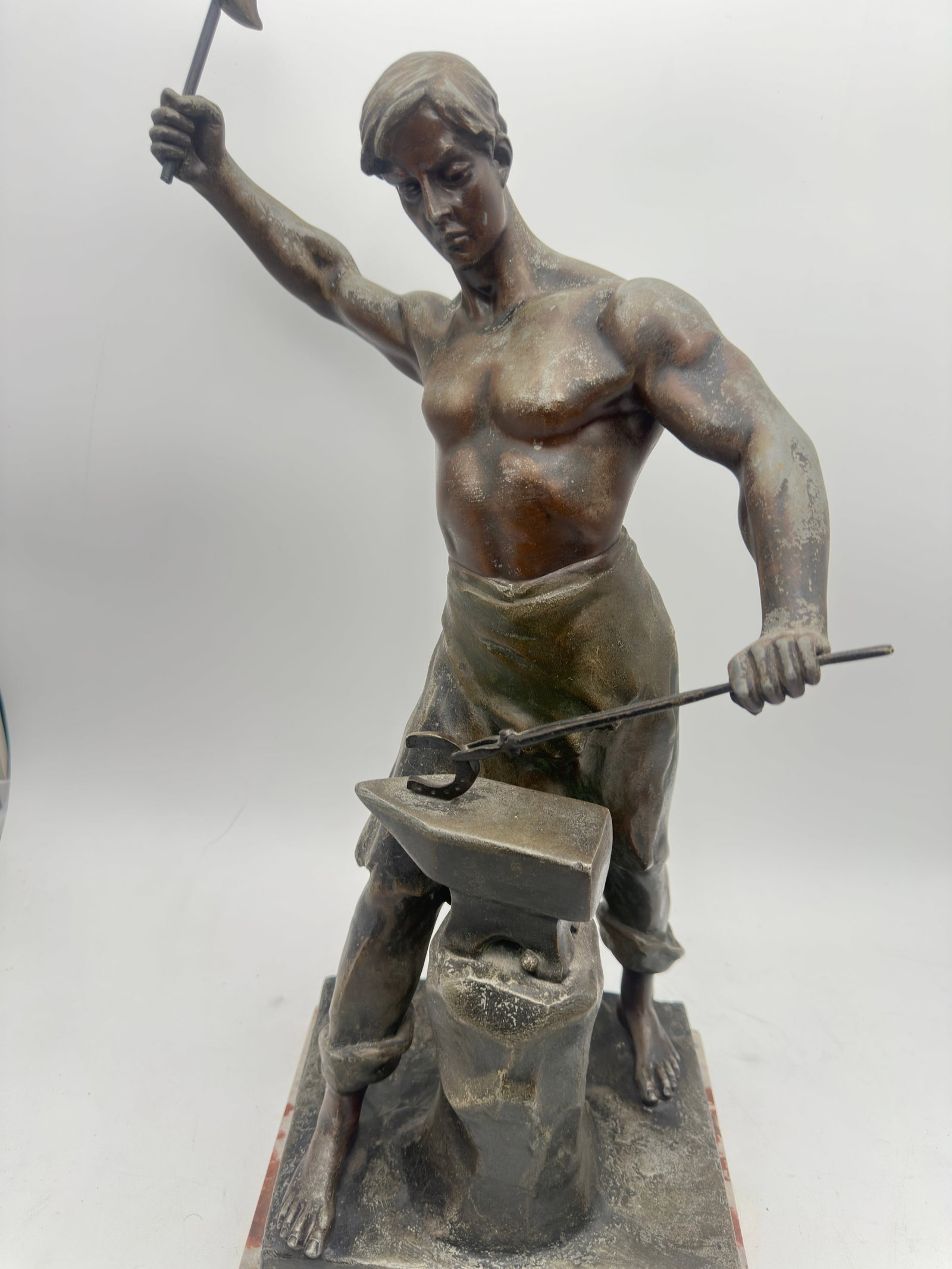 Metal sculpture - Work - signed LEMOYNE (late 19th/early 20th century) H: 55cm on a base: A finely modeled figural sculpture depicting a young blacksmith engaged in his craft, shown striking heated metal upon an anvil. The figure is rendered with strong anatomical detail and a dynamic pose